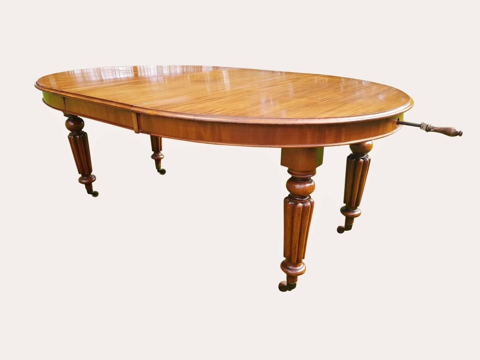 Very good quality antique Victorian Mahogany wind out dining table, with an extra leaf. The colour is a well figured Mahogany, and being original of mellow color. 

The table stands on reeded and carved legs with the original castors.  As can be