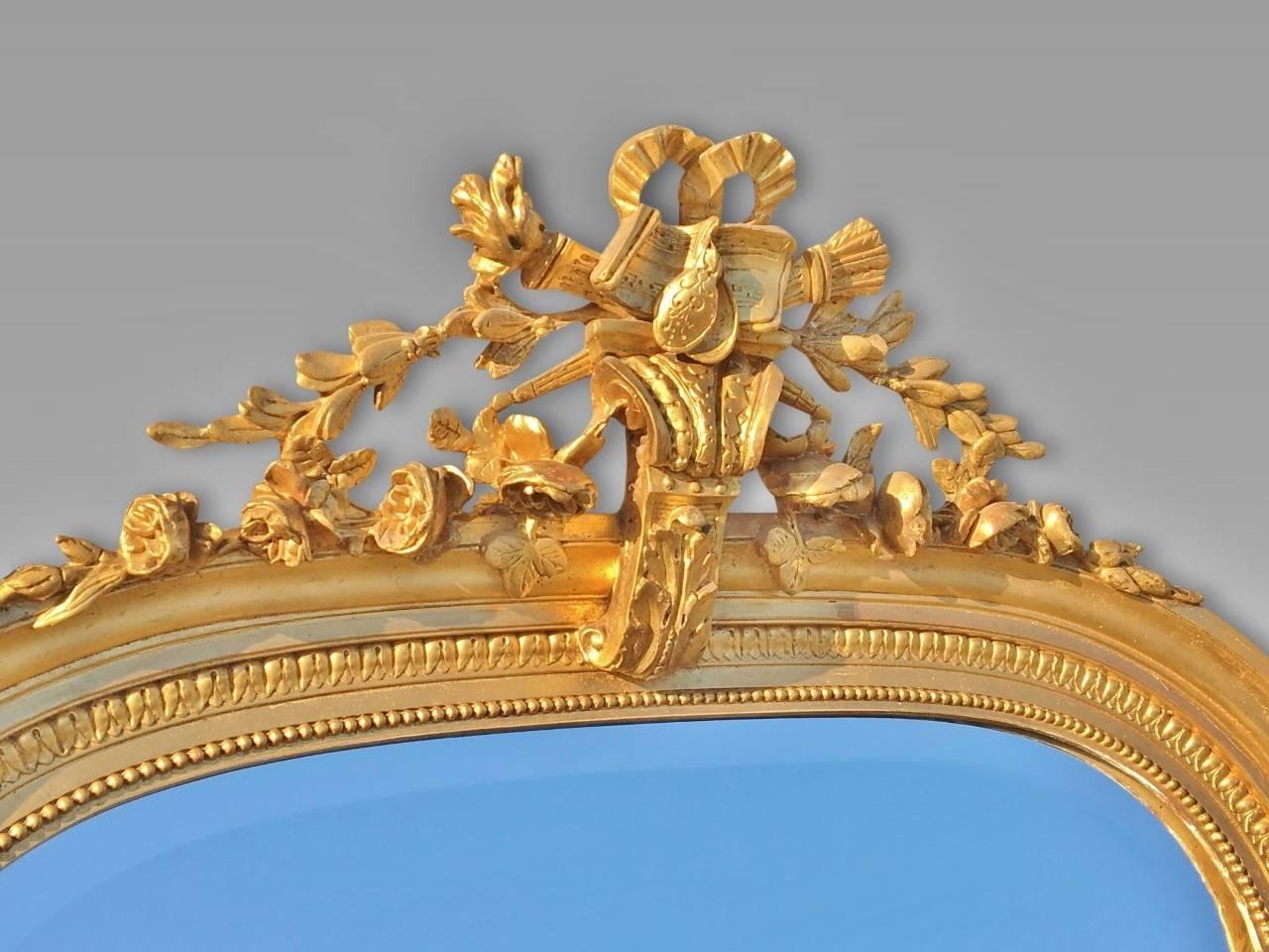 Very smart antique gilt wall mirror / overmantel mirror. French and dated circa 1890.
This delightful mirror is in fine condition with attractive gilding and carving / mouldings to the crest atop the mirror. The mirror glass is clear, bright and