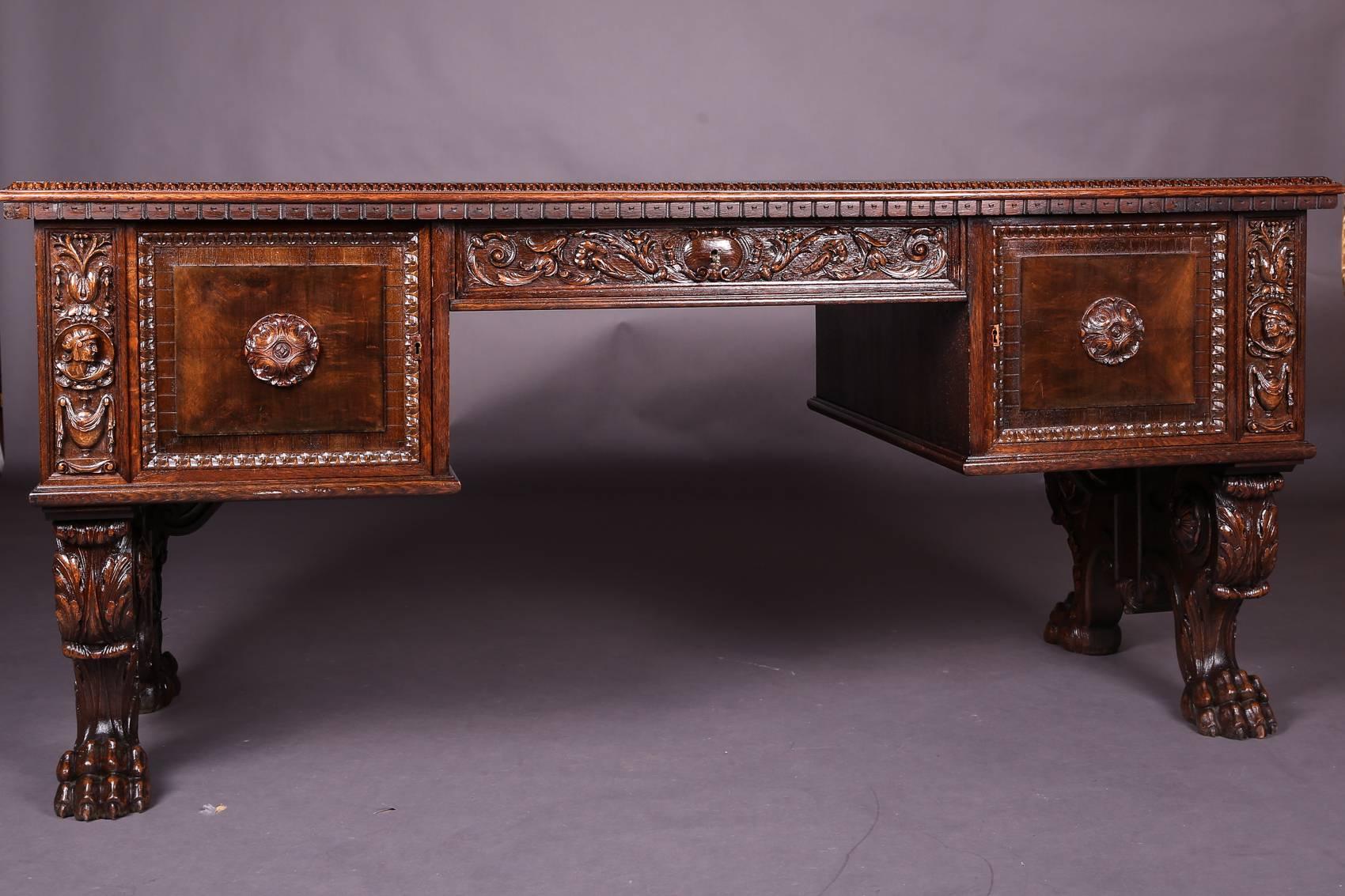 Masterly oak desk. Solid oak carved. Slightly protruding top plate.
Desk standing on paw shaped feet. Extremely rich and finely carved.

(L-125).