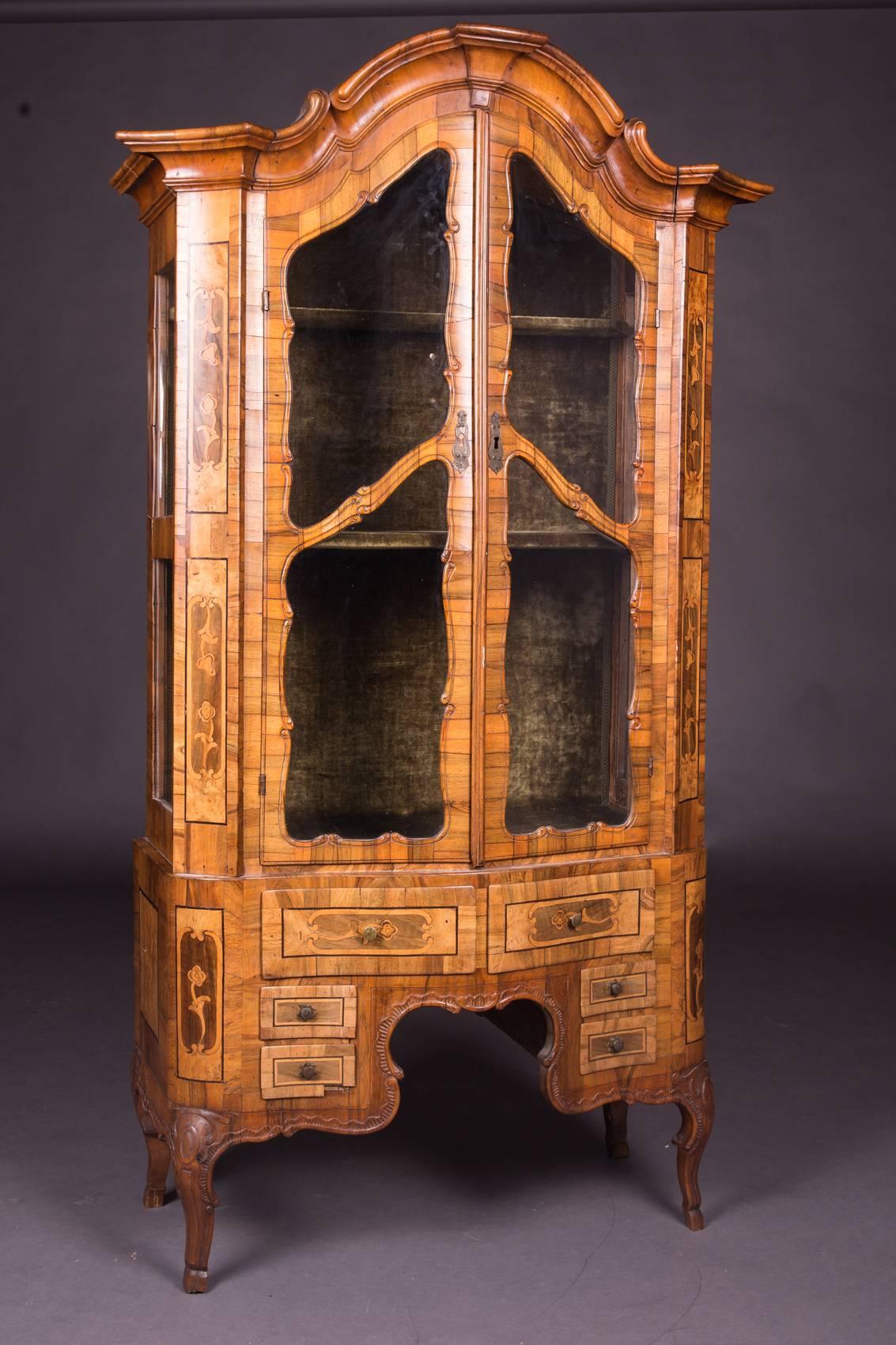 Baroque cabinet, 18th century walnut and other precious wood veneered and inlaid, standing on small legs, strongly curved body with six drawers, two-door, glazed glass cabinet with bent head. Partially. Floral inlaid framed veneer panels. Inside