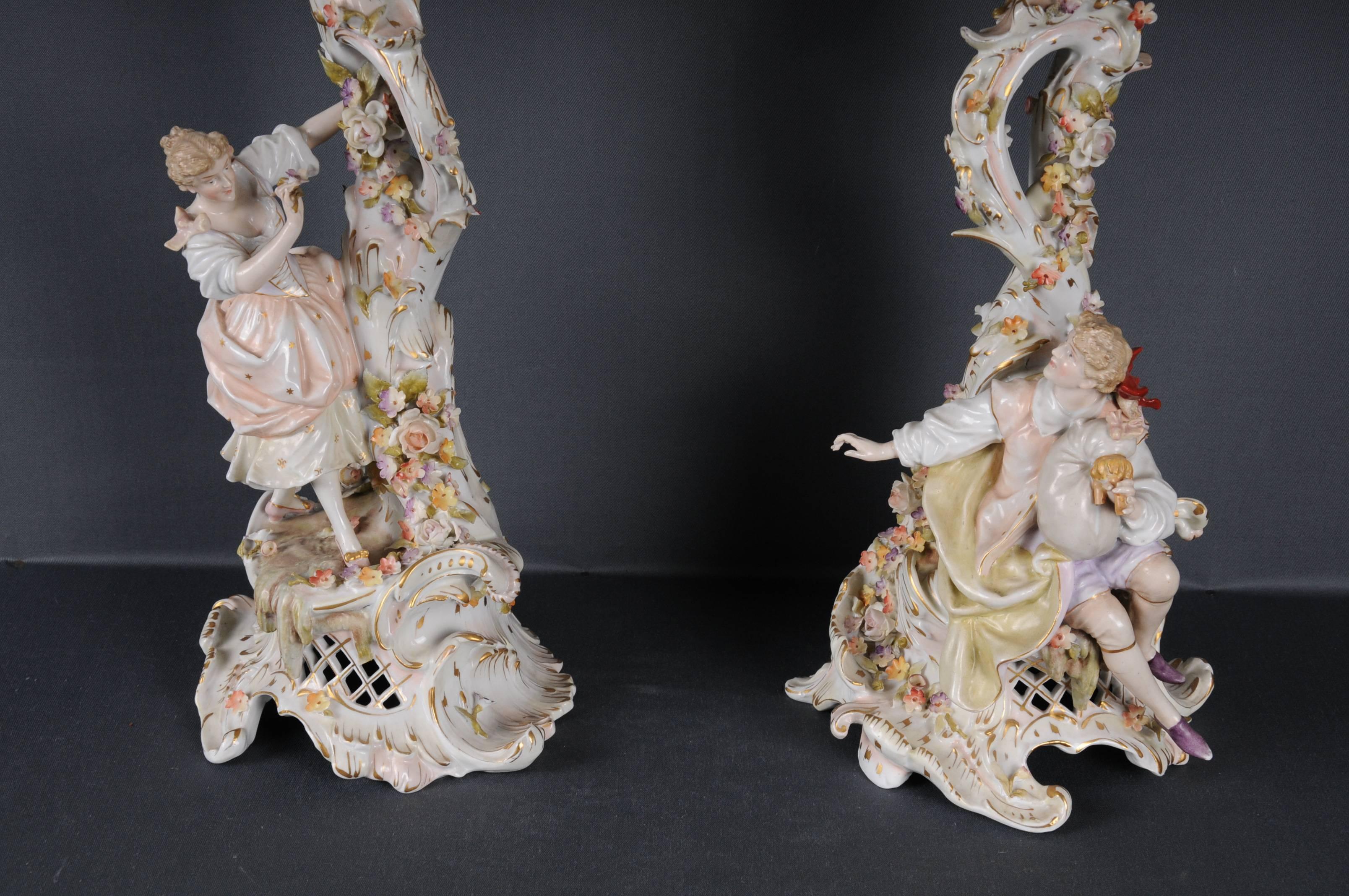 Pair of decorated porcelain chandeliers. Both chandeliers are richly decorated with plastic flowers and leaves.
The candle couple embodies a romantic love scene in the style of Rococo. Branch-shaped body with wide base. Rich gold staple. Each