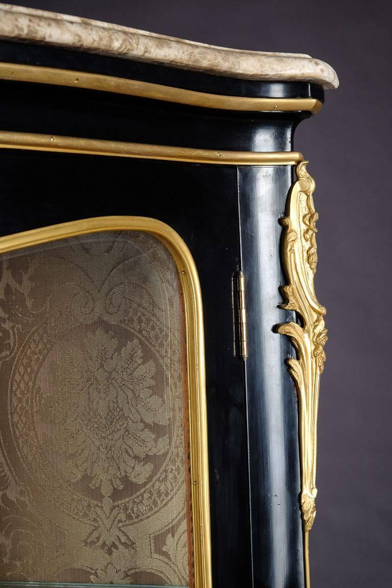 Petite French vitrine in the style of Louis XV Rococo piano black polished veneer on solid beech. High-rise, one-armed, cambered body, three-sided to three-section, on high slanting, curly feet. Profiled cornice with marble top. Inside two glass