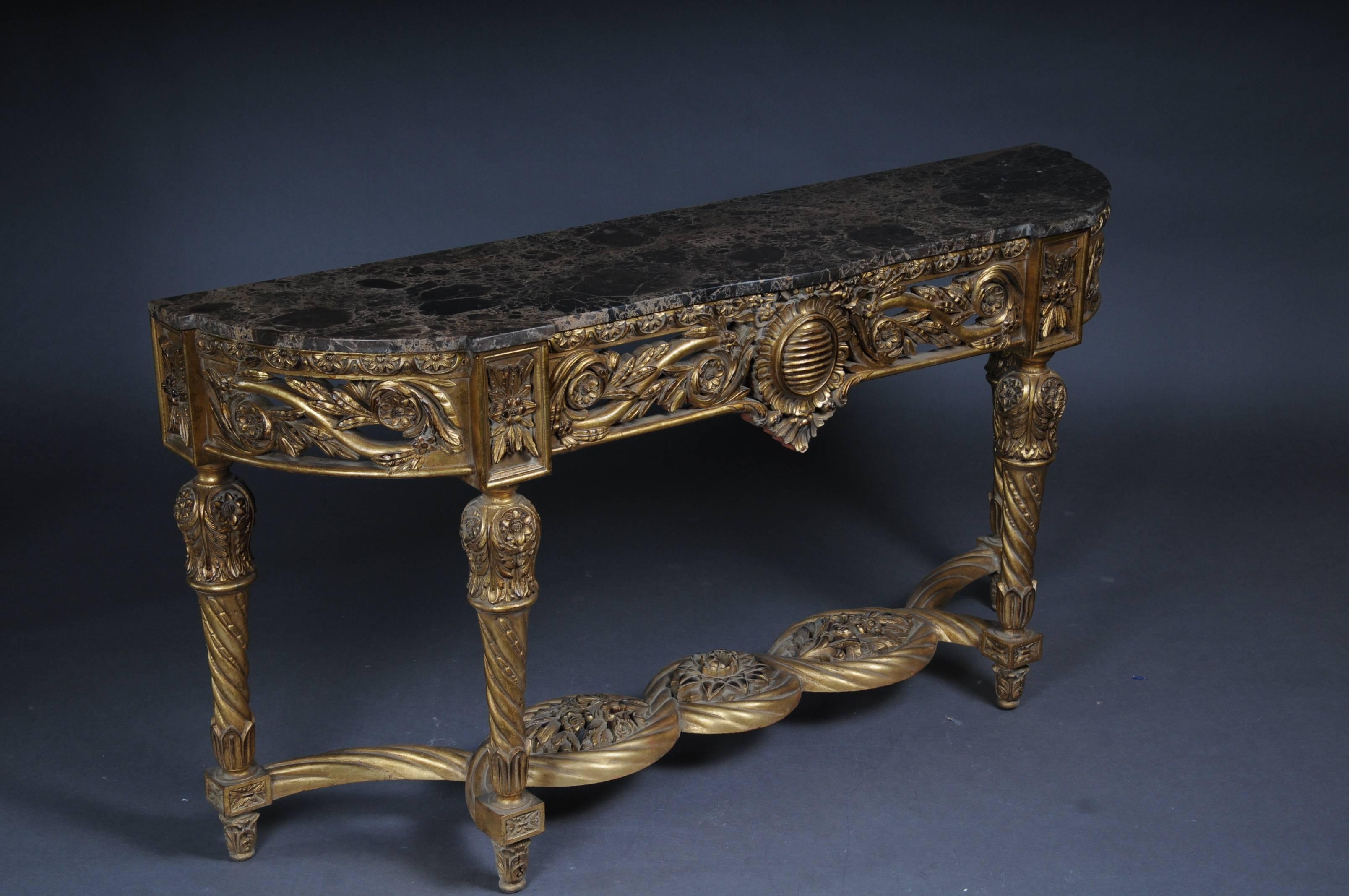 Solid beechwood, finely carved and gilded. On high slanted volute-like rolled feet connected with crossed richly carved middle bridge. Scalloped side frame. Overhanging mottled marble slab. Rich gable-like openwork rocaille crowning.
On conical,