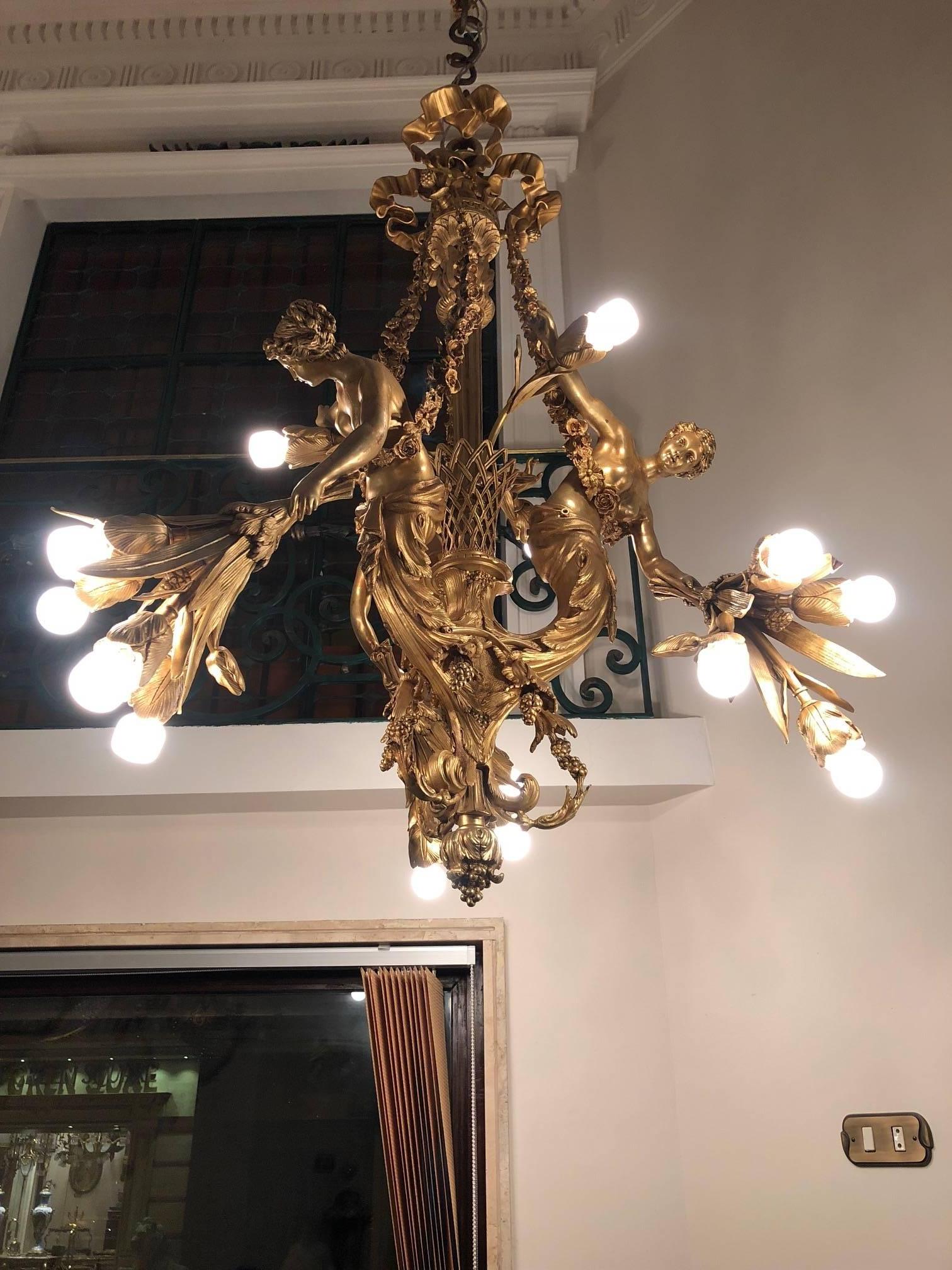 Finely chased and gilded bronze. Extremely rare and decorative chandelier made of solid bronze fire-gilded. Body flanked by three ladies holding a bunch of flowers in the form of candlesticks. Completely electrified.

Measures: Height circa 43.30