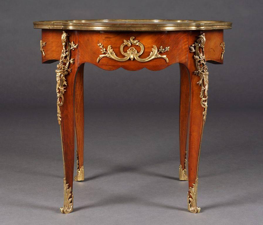 Mahogany on solid oak, slightly convex and concave-curved body, flanked by extended corner irons on tall, elegantly curved legs in sabots.
Cover plate with mottled marble (torn in the middle) in a brass frame. Perforated seed beads and