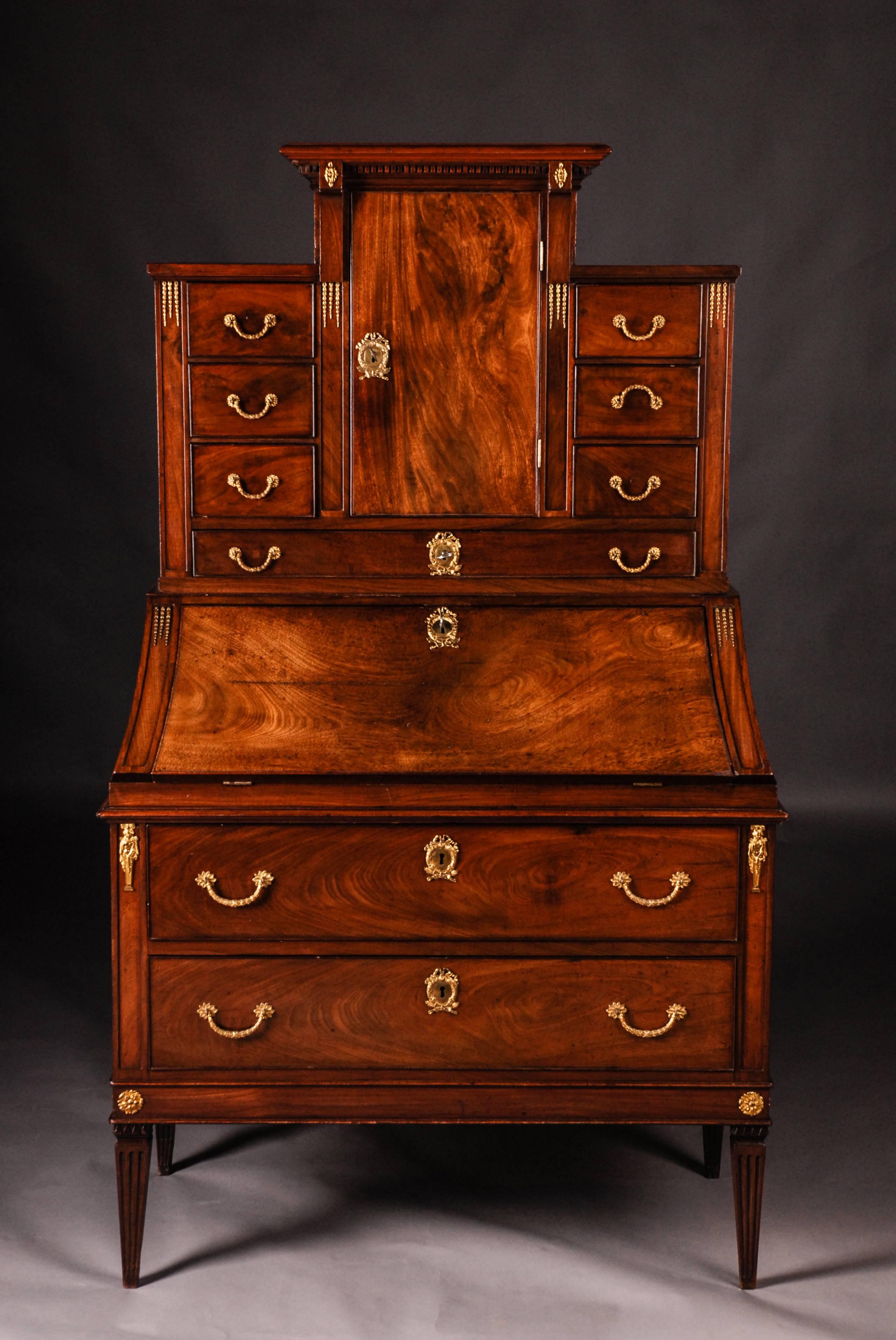 Mahogany on softwood. Fireproof fittings.
Rectangular body on conical squares. In the front two wide drawers. Inclined, hinged writing board, behind it richly divided office division. Writing board is felted with felt. Revised essay. In the front a