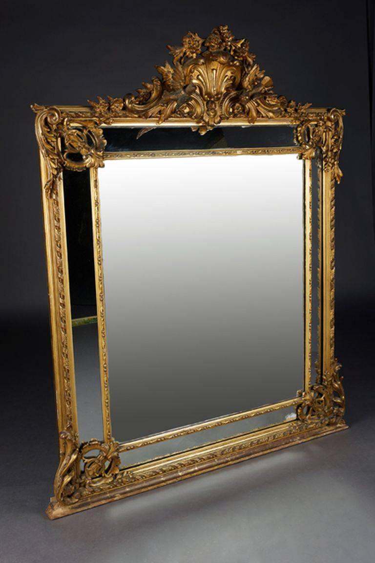Massivholz und Stuckblech vergoldet. Hochwertige, facettiert geschliffene Spiegelgläser in einem profilierten Rahmen. Das Giebelfeld ist mit klassizistischen Skulpturen geschmückt. Hinzu kommen die Seitenrahmen, die in einzelne
