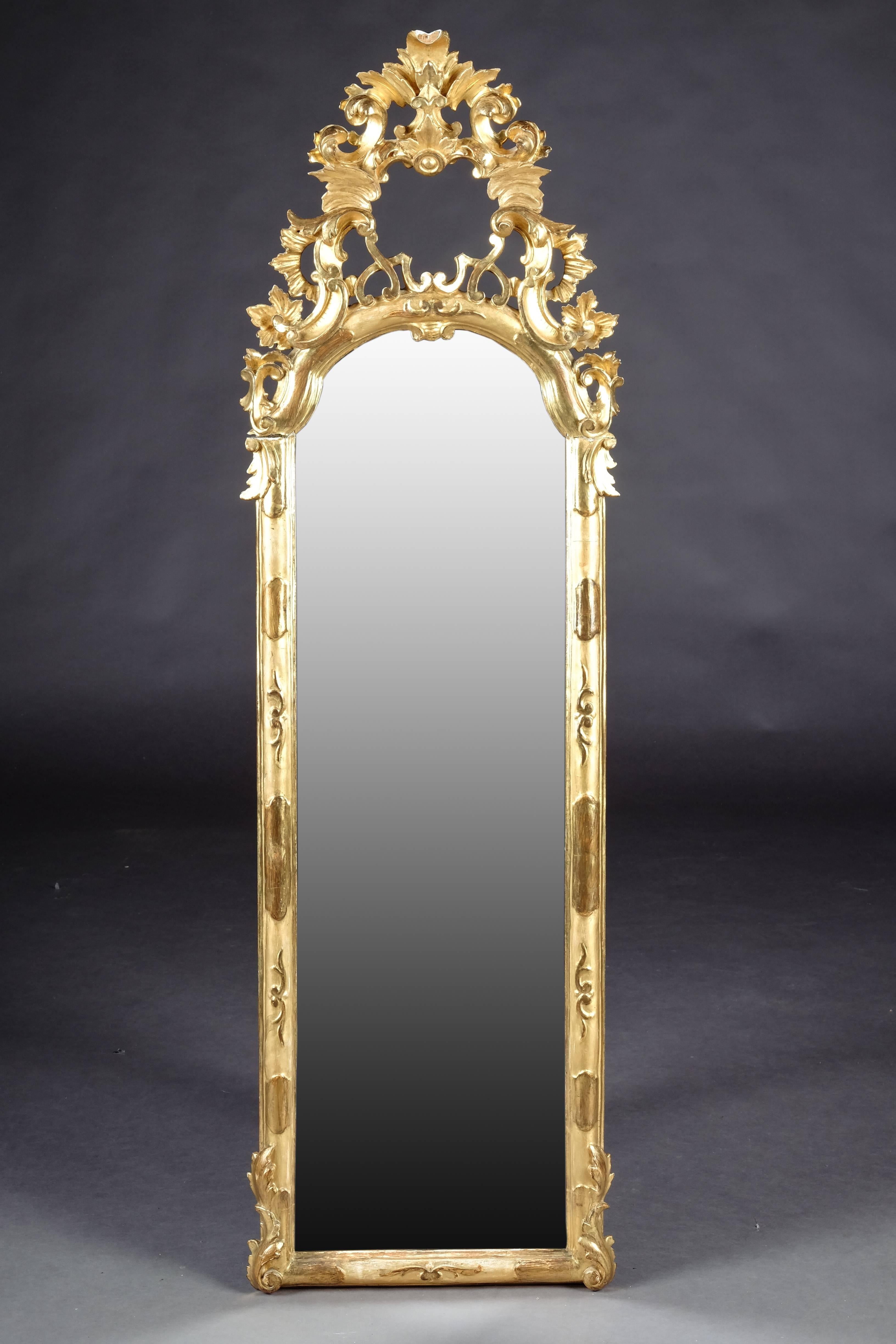 Solid wood carved and leaf gilded. High-quality mirror frame. The Giebelfeld is decorated with sculptured carved Baroque elements.

(M-18).