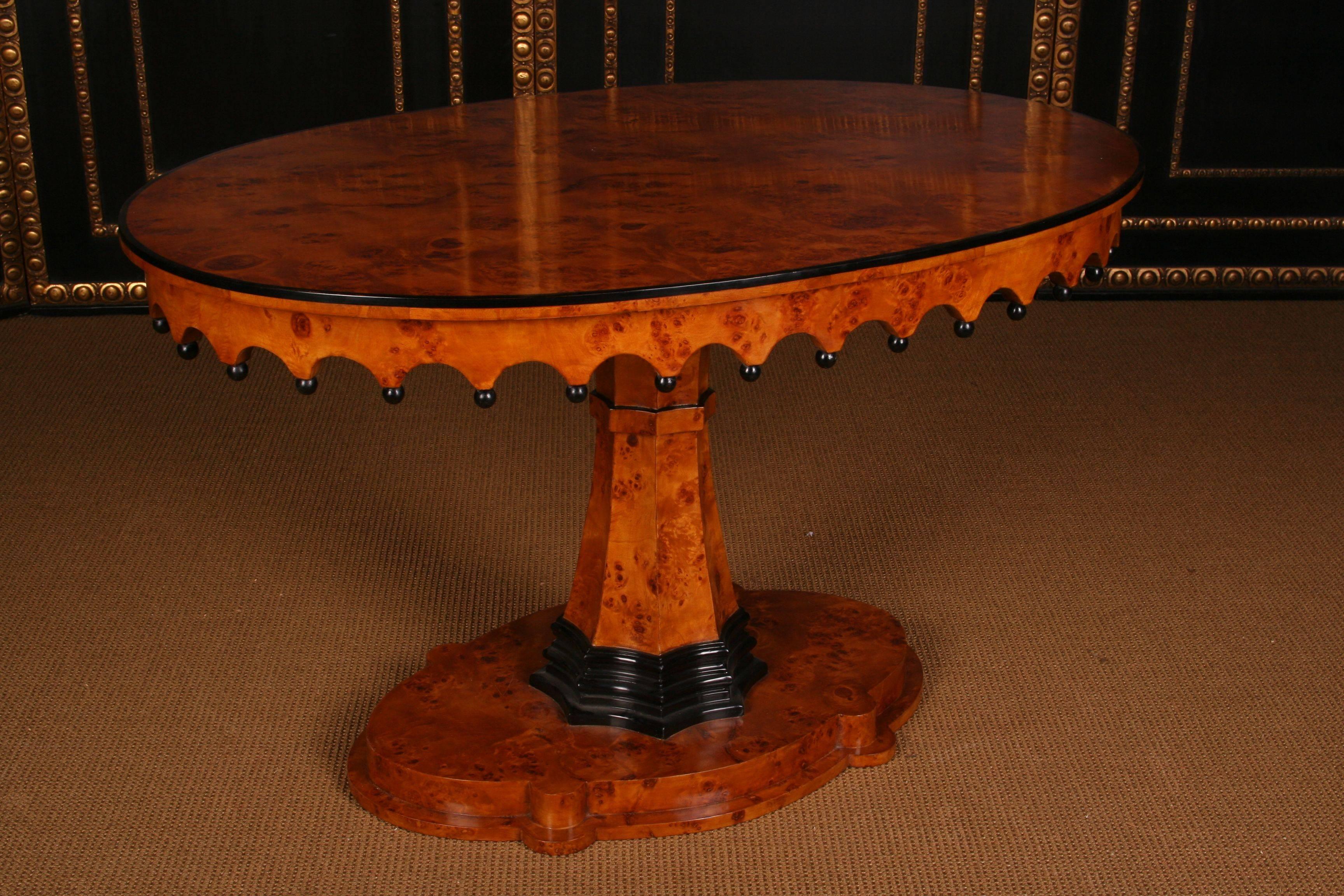 Exceptionally pretty oval table in Biedermeier Style.
Bird’s eye maple on solid wood, partially blackened. Oval cambered and profiled pedestal. Middle ascending, eight cornered fan-shaped column shanks, partially blackened. Gothic border with