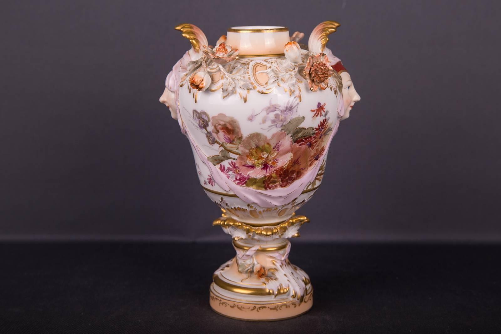 Very elaborately painted and decorated corpus. Two-sided flower bougies in soft painting. Potpourri vase flanked with a female mask image. Above the corpus, the vase is filled with plastic flowers, leaves and buds.
Very rare and old vase.
KPM