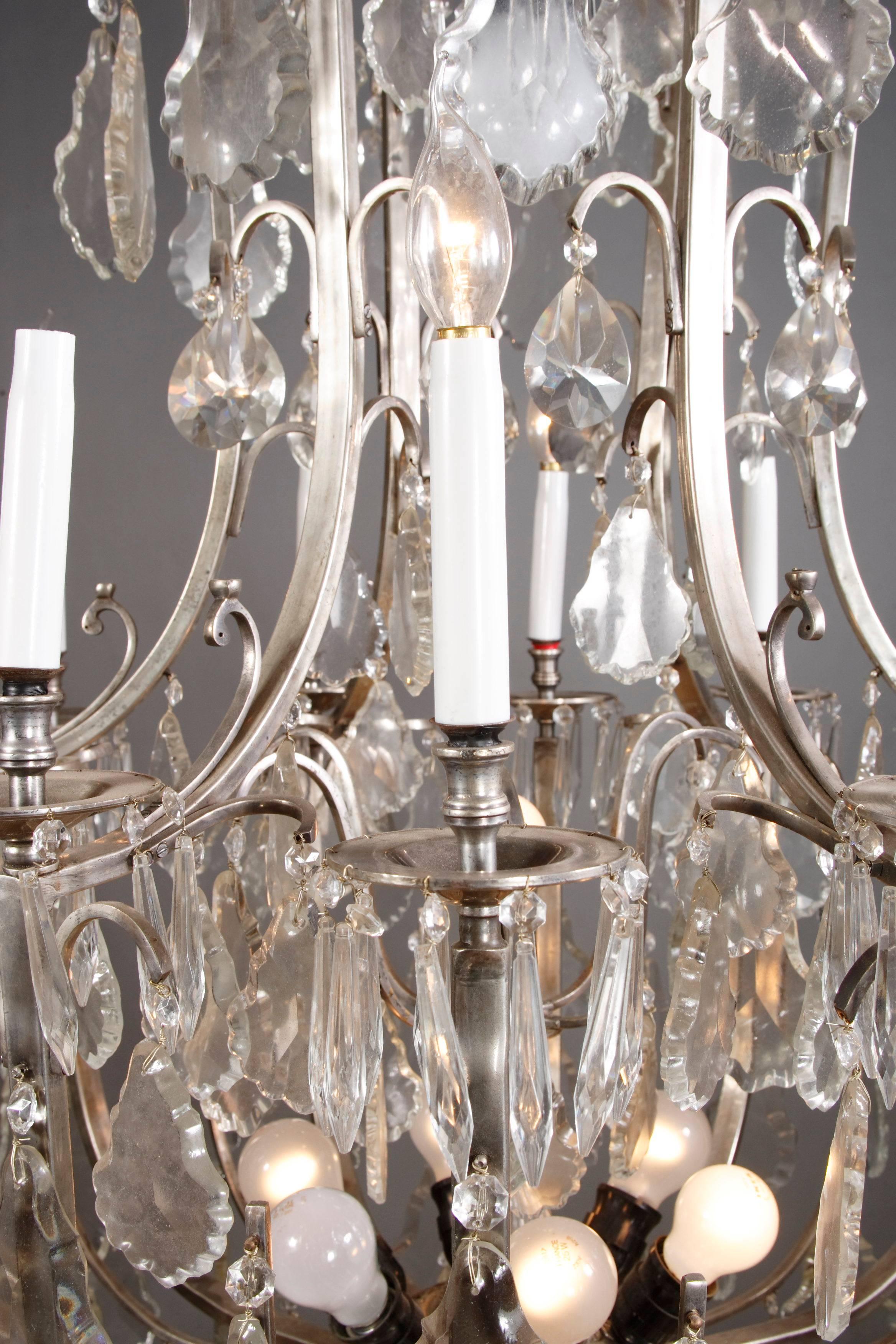 Large French chandelier.
Brass, silvered. Finely ground crystal. 12 curved light arms.

(F-Hud-1-si).