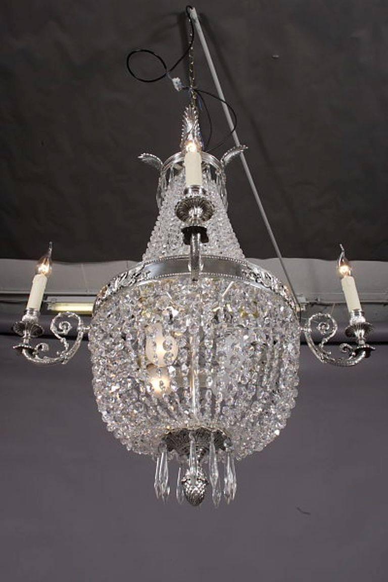 Basket chandelier in Biedermeier style.
Finely engraved, silver gilded brass. Hangings from finely ground crystal.

(F-Ra-28).