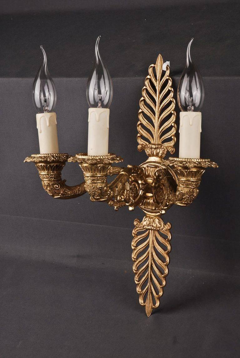 Decorative wall light in Empire style.
Finely engraved and cast bronze. Three stylized, full horn-formed, sweeping light arms. 

(F-Sam-1).