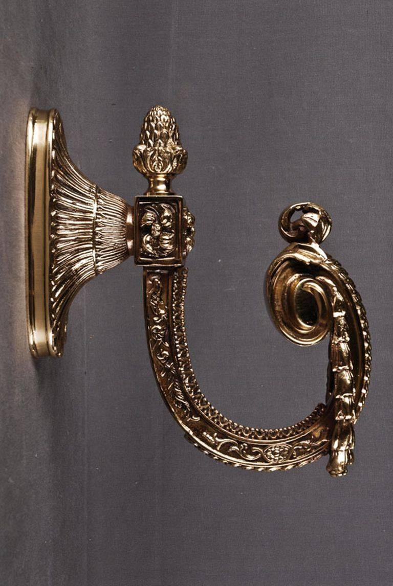 French curtain retainer in Louis XVI style.
Bronze, finely engraved. Relieved wall plate, before engraved scroll with garlands as curtain retainer.

(X-Mr-26-Bp).
 