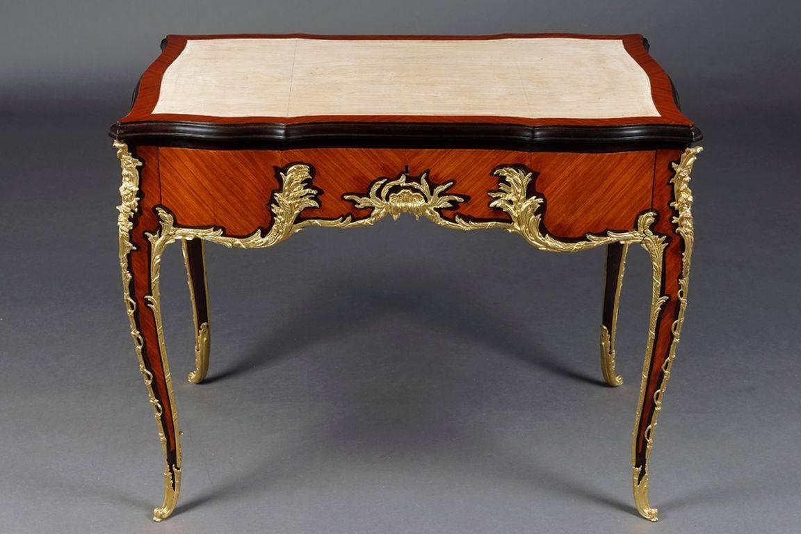 French Bureau Plat in Louis 15th Style after Francois Linke.
Rosewood and shadowed noble woods, veneered. Exceptionally Fine floral, Bronze fixtures. Strongly bowed, four sided, curved, three drawered border with wide knee area on elegant, curved,