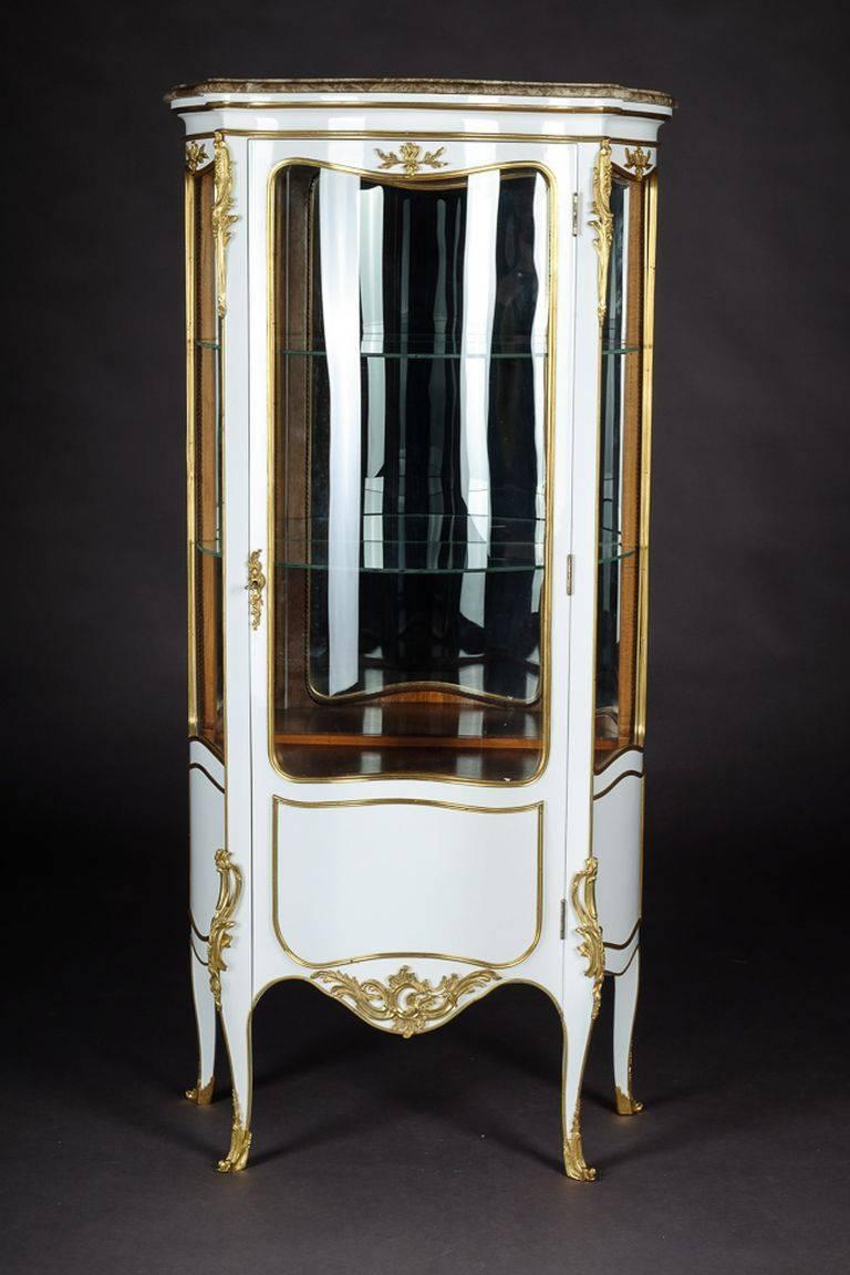 Petite French vitrine in the style of Louis XV Rococo
Piano white polished veneer on solid beechwood high-octagonal, one-armed, curved body, three-sided to three-section, on tall, slanting, curly feet. Profiled cornice with marble top. Inside two