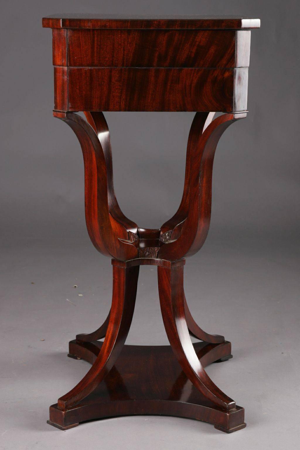 Highly interesting Biedermeier sewing table, circa 1820.
Mahogany on solid beechwood. On strongly curved cross-legged legs, joined by a slightly interlacing intermediate part, and then saber-shaped legs on the four-legged, base plate on disc feet.