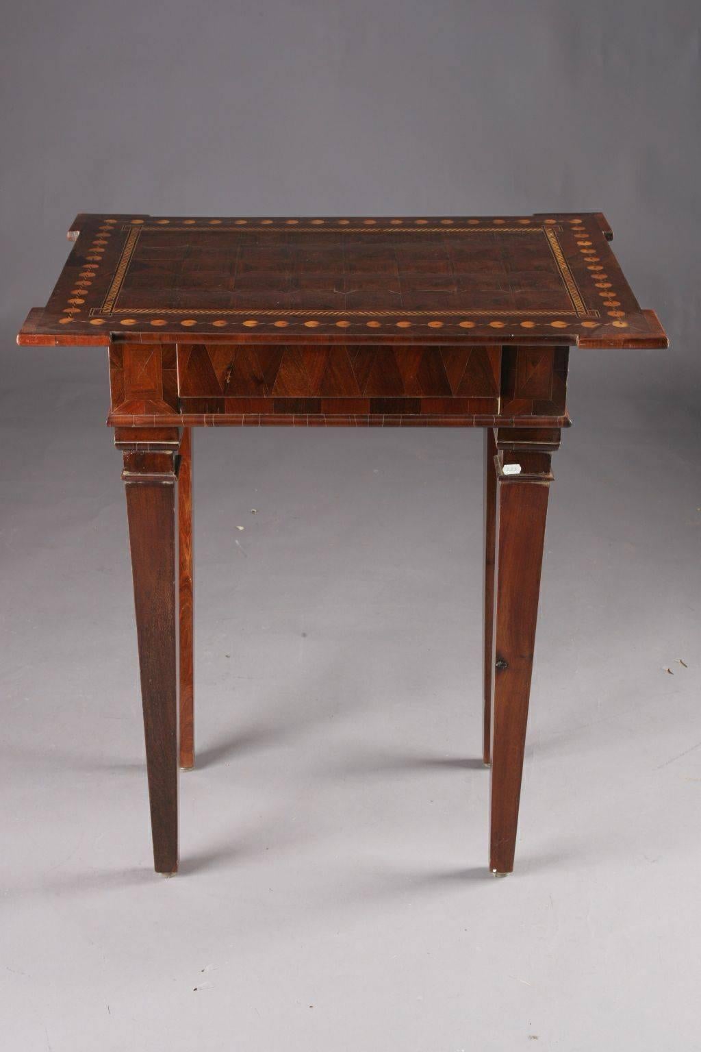 Sensational side table from the classicism, circa 1790.
 oak. Straight-edged frame base on four pointed tines. The tabletop, which is folded at the corners, with a diced inlay work, depending on the viewing angle, results in a fascinating 3D