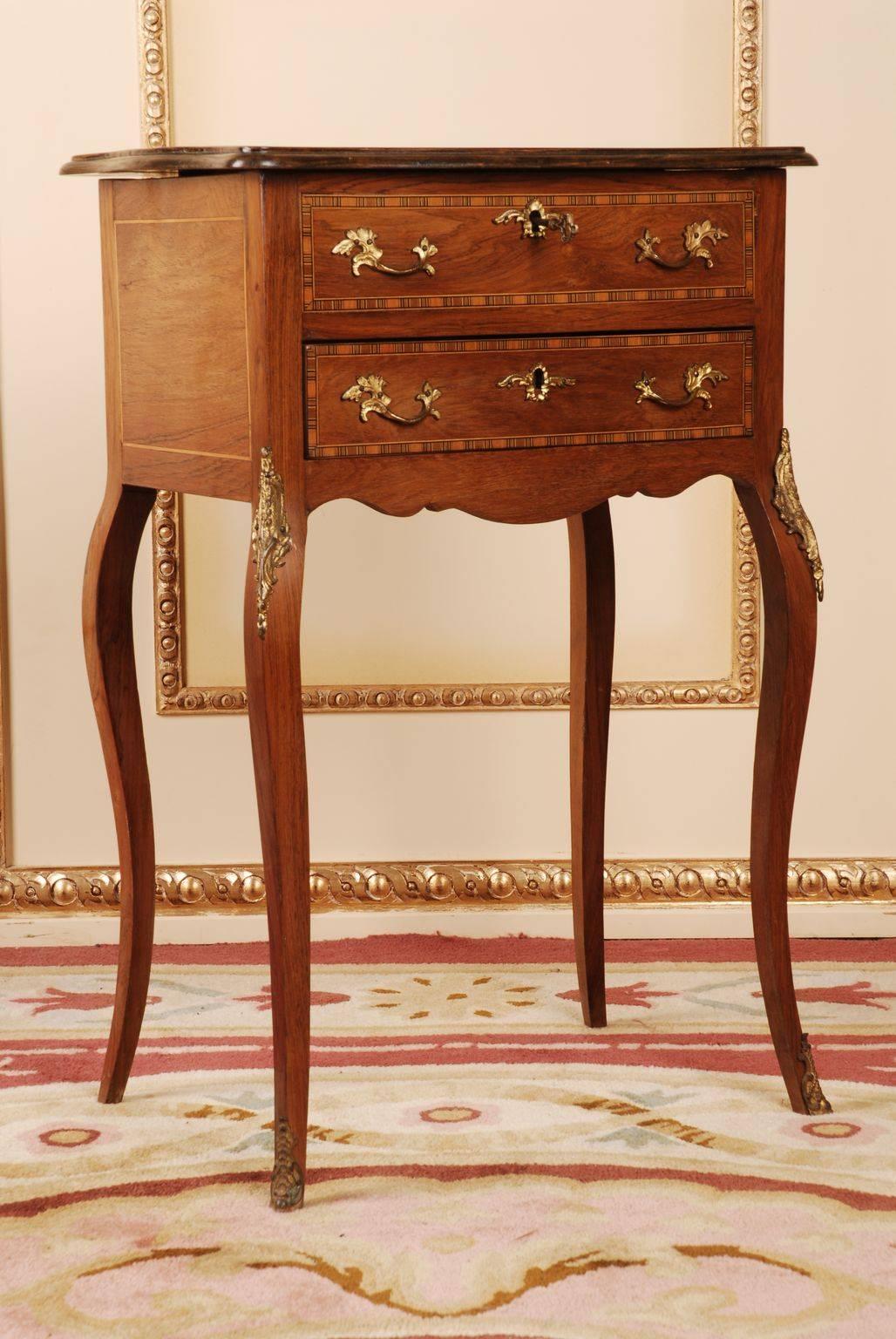 Elegant side table in the Louis Quinze style.
Rosewood on pine. The whole corpus is inlaid. Slightly protruding top plate on two-waisted cambered frame on curved legs. Rich bronze fittings.

(G-41).