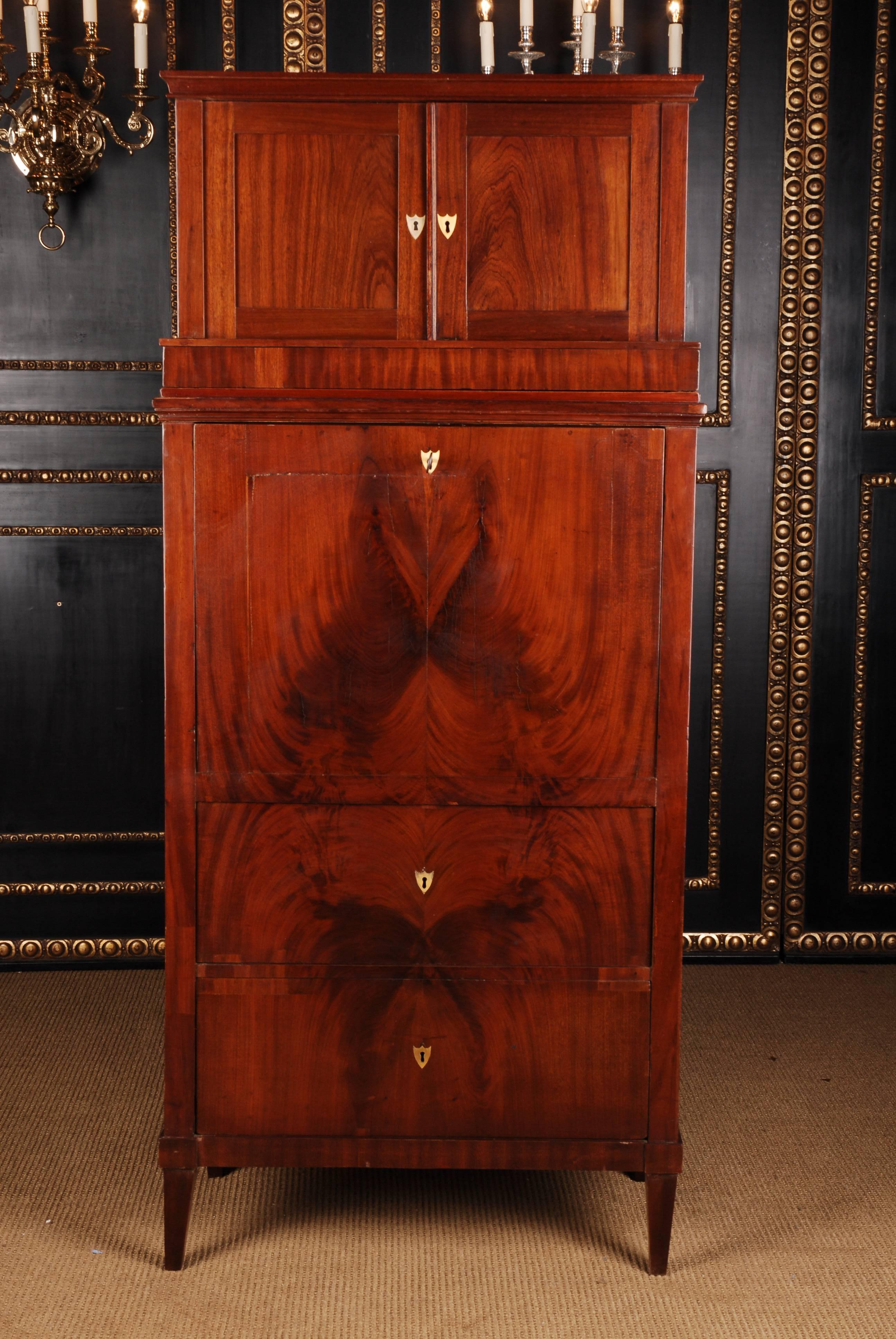 Petite secretary Biedermeier style, circa 1790.
High-quality Cuba mahogany on solid softwood. High-right body on tapering legs. Supplied with three drawers of different sizes. Straight writing plate, which is fogged with natural leather and embossed