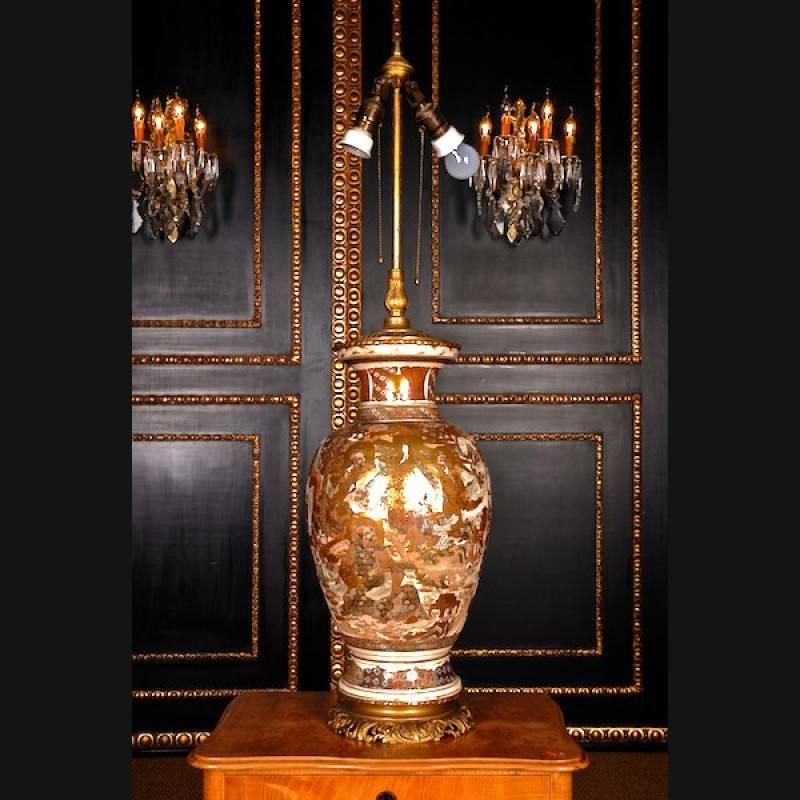 Monumental table lamp with bronze mount Japan, circa 1880.
Porcelain. On round fine-grained and perforated mount. High ovoid wall, short cylindrical neck. On the front richly painted in it many-figured scenes. Electrified.

(F-40).