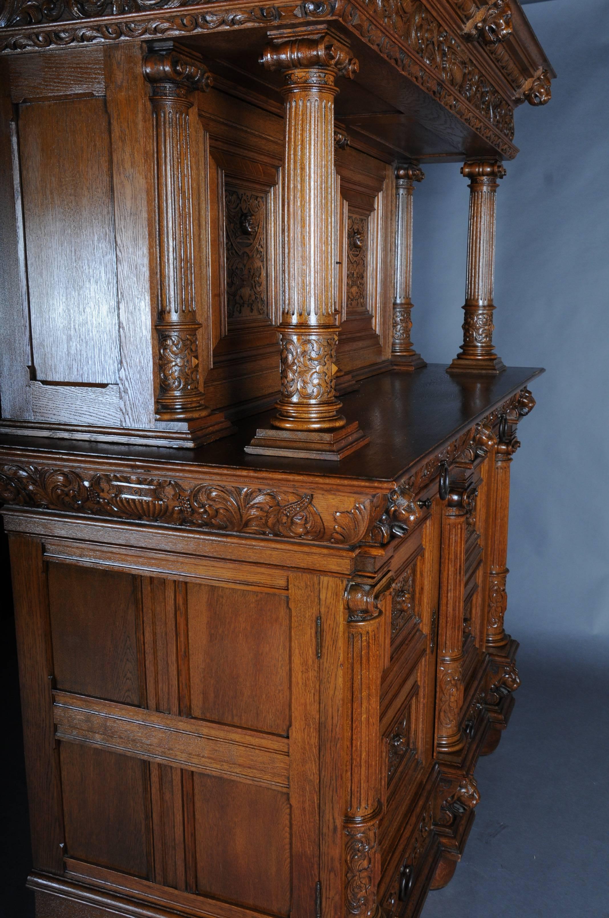 Oak, solid. Architecturally built and richly decorated. The two-door casted basement with a total of four drawbacks and finely carved mascarons and acanthus leaves, laterally with plastic, meshed, ionic half-columns. Underneath the upper drawers,