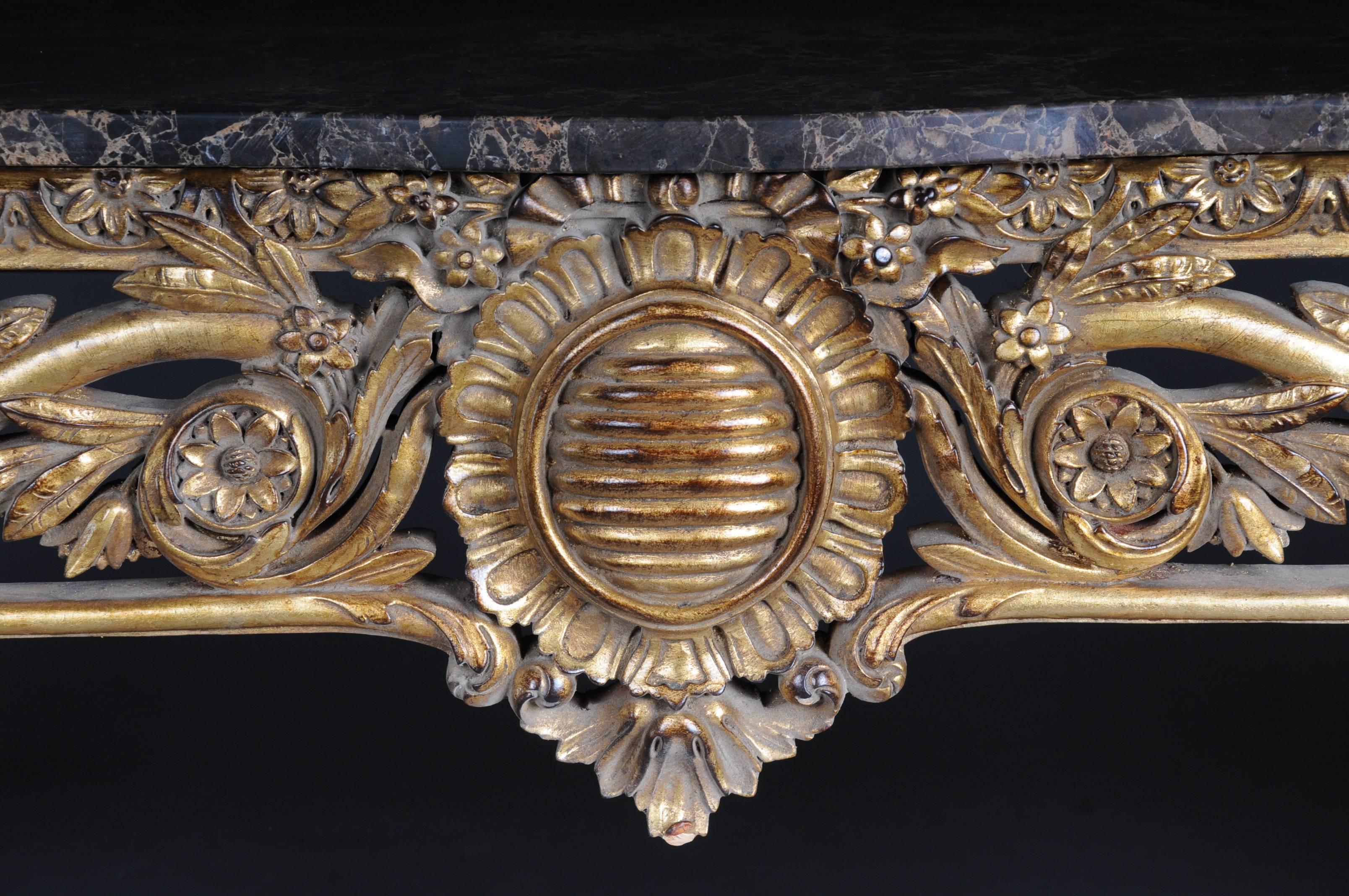 Mirror richly carved solid beech wood mirror frame and gilded.
Console: Solid beechwood, finely carved and gilded. On high slanted volute-like rolled feet connected with crossed richly carved middle bridge. Scalloped side frame. Overhanging mottled