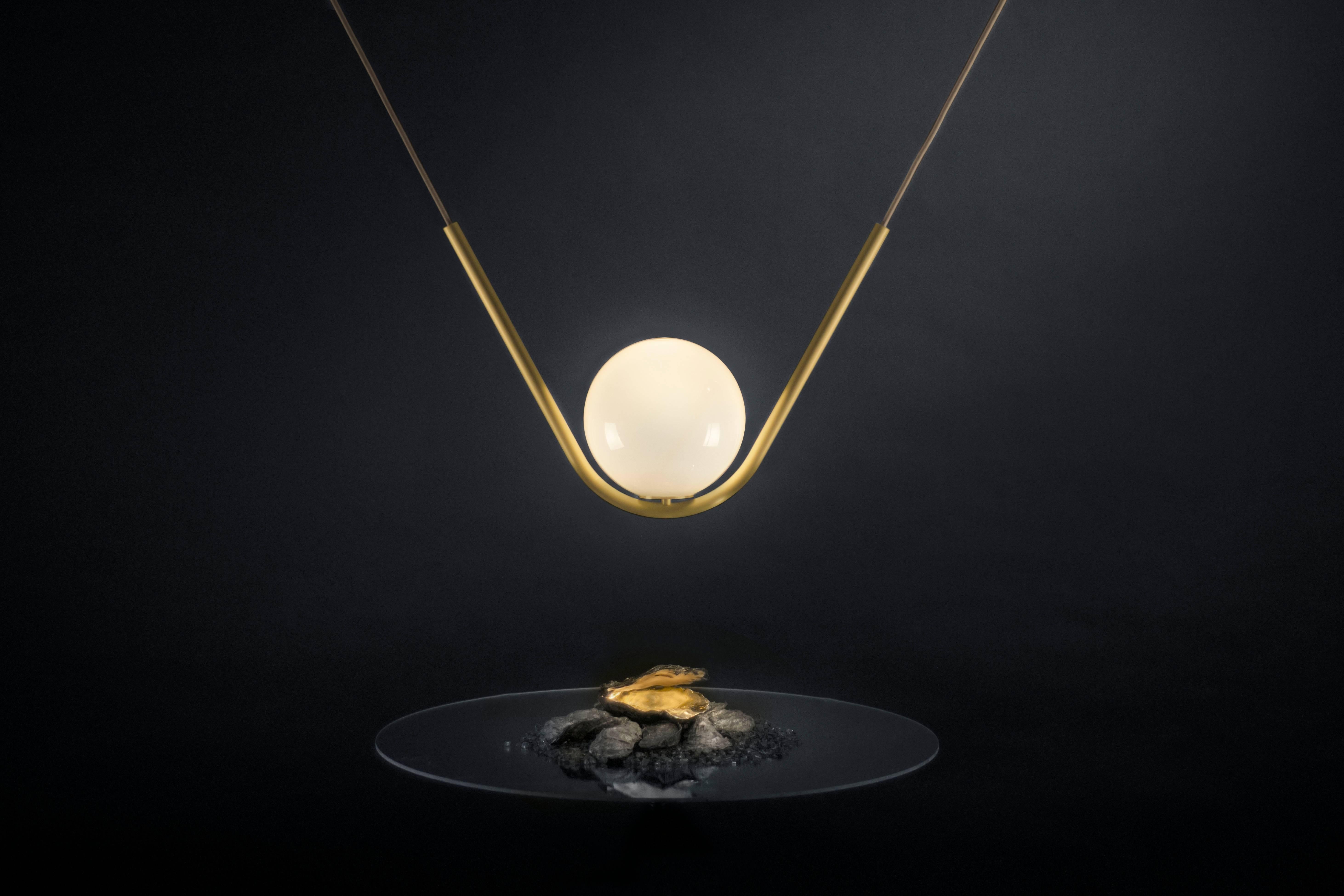 Perle 1 is a luxurious high-end lighting fixture that has been coated with warmth and elegance. Inspired by the romantic world of jewelry, the Perle collection is handcrafted with a delicate metallic structure and a 8’’ hand blown glass ball as the