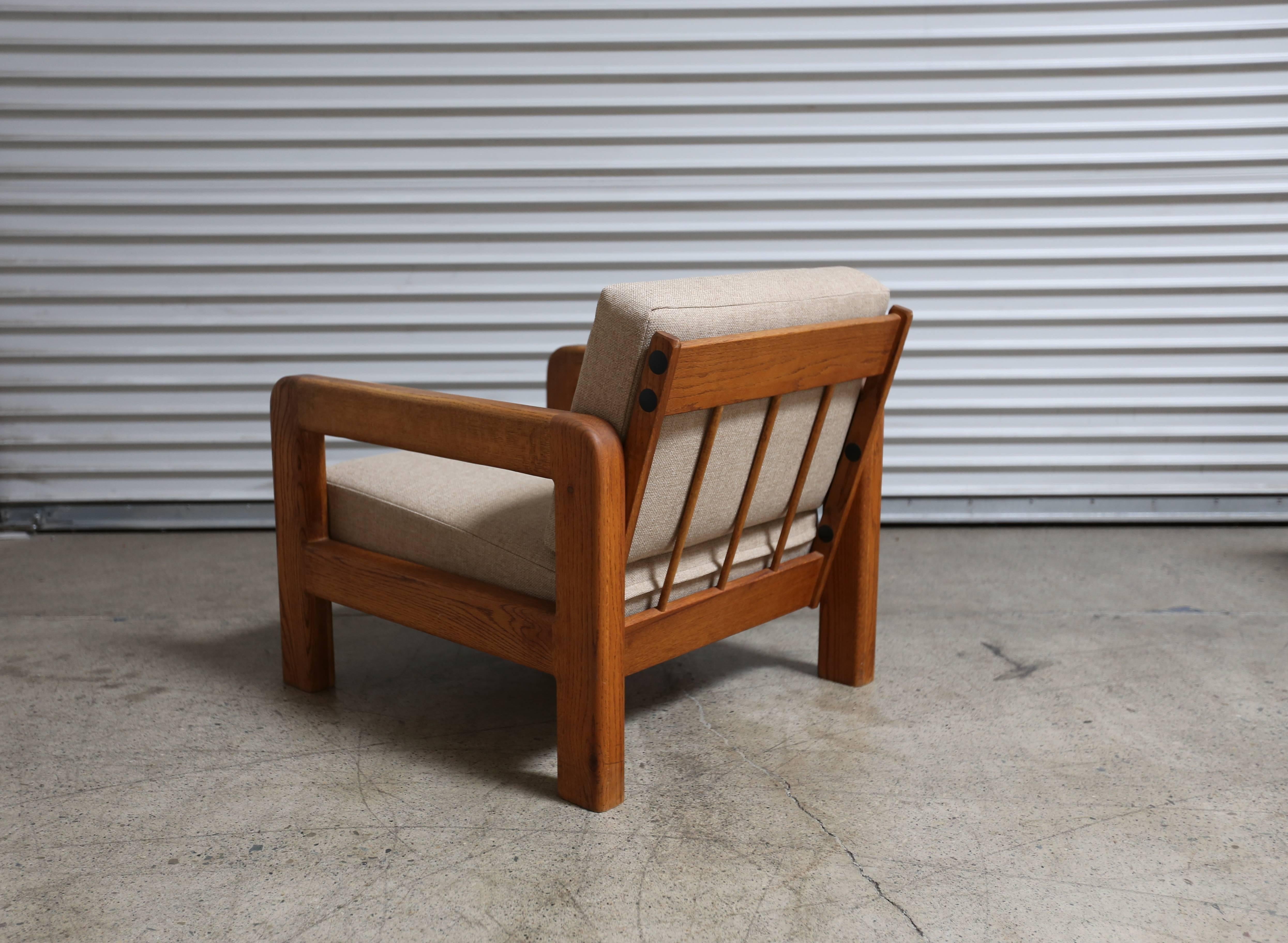 Pair of massive oak armchairs in the California Mid-Century Modern style with upholstery.
