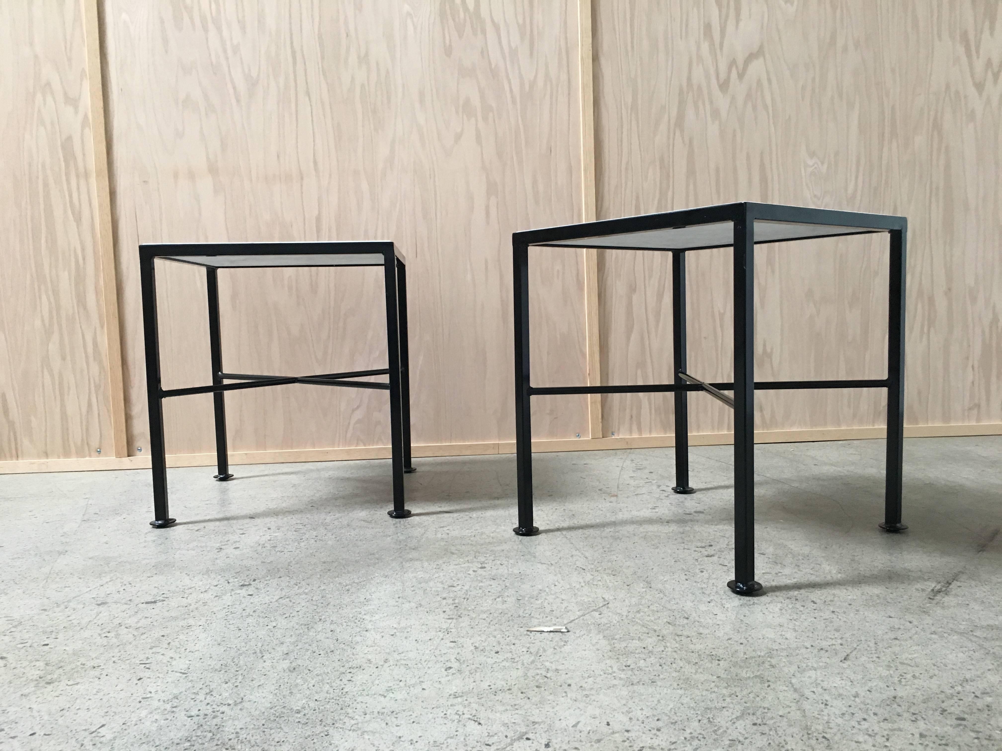Pair of modernist end tables with X base and powder coated base and white marble-top.