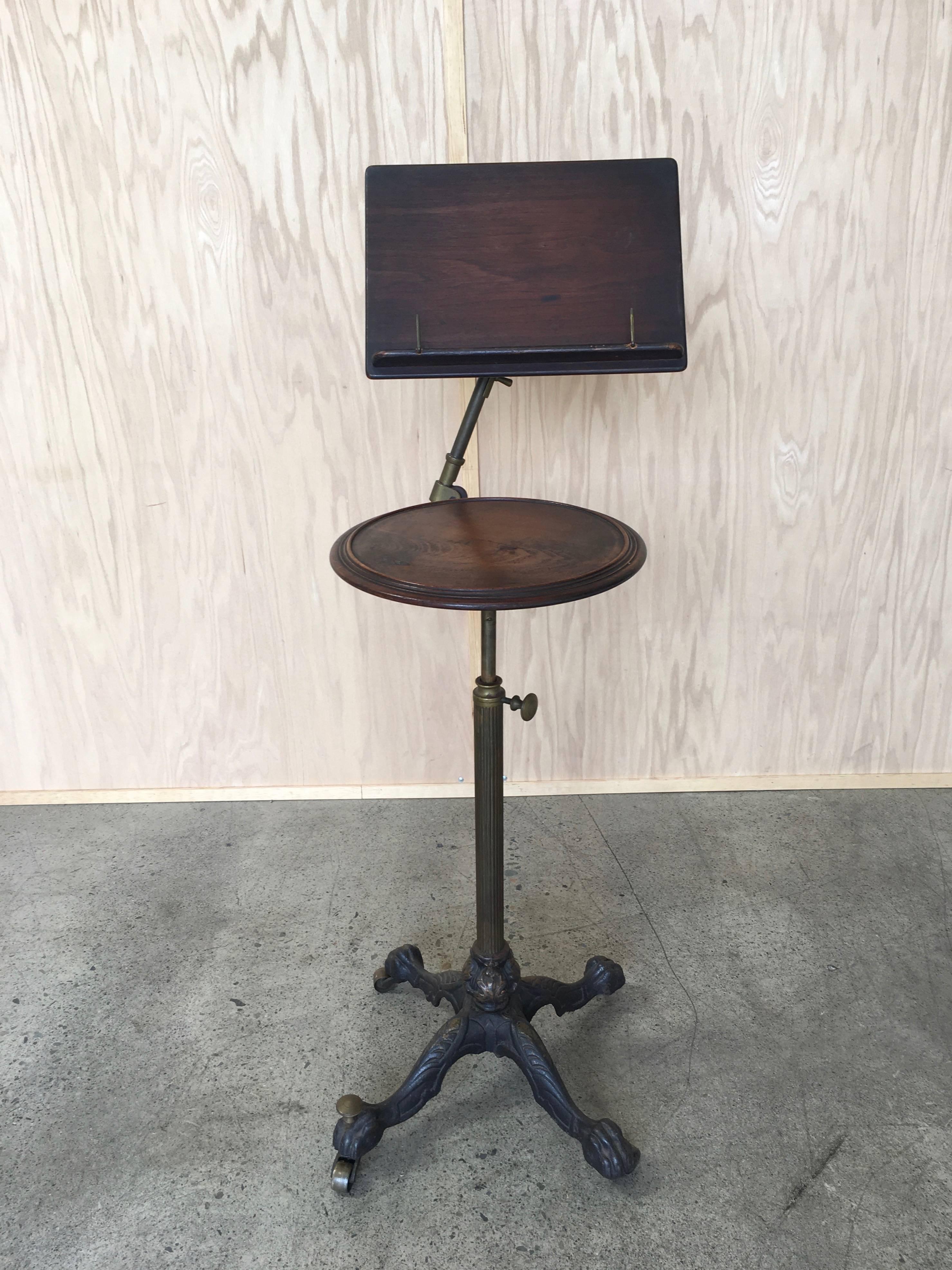 Antique
19th century articulated music candle stand 
Cast iron base with fluted brass column leading up to the mechanism 
for adjusting height of candle table and the music holder.