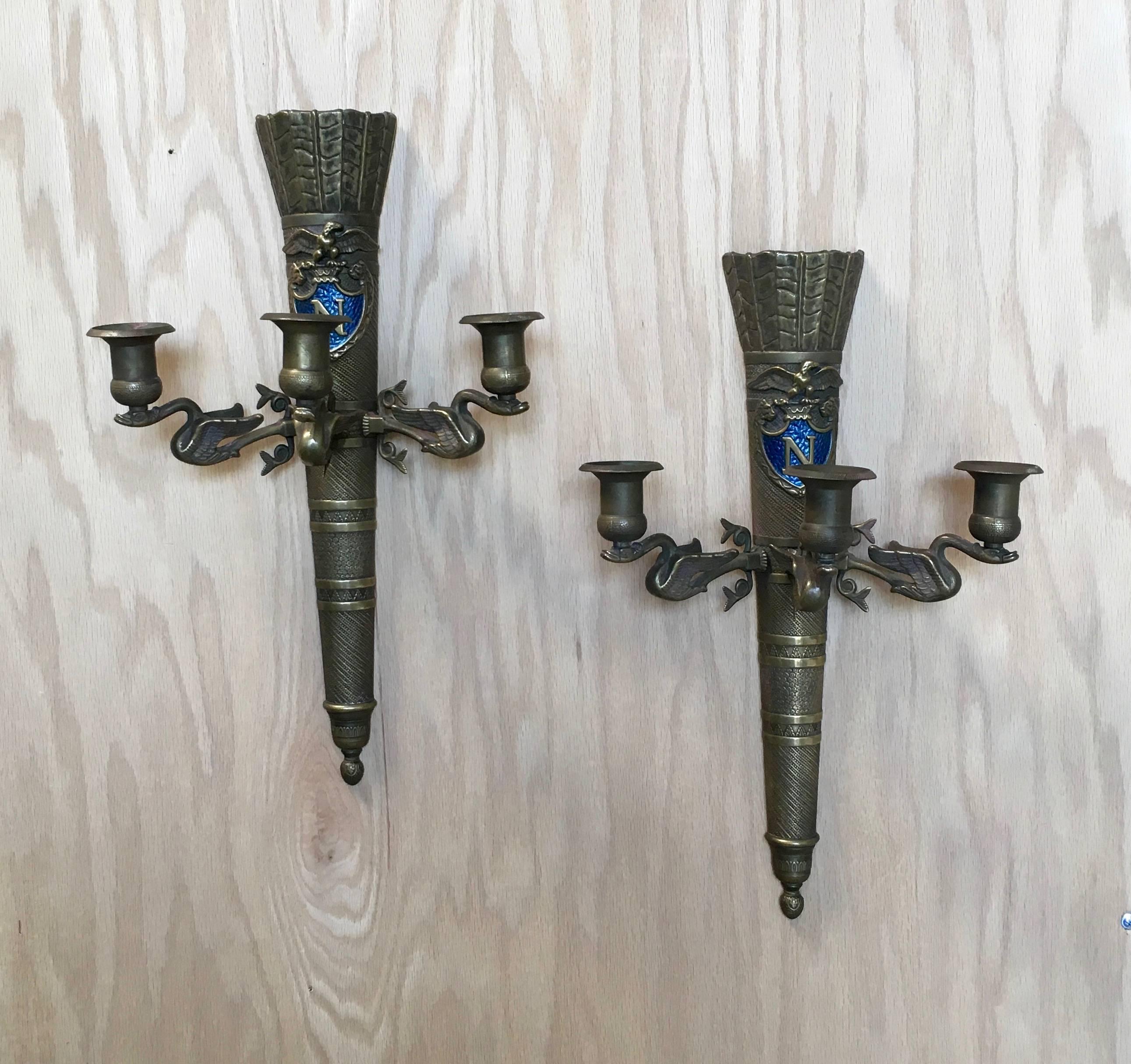 Pair of brass antique neoclassical Revival sconces with the royal blue Napoleon symbol.