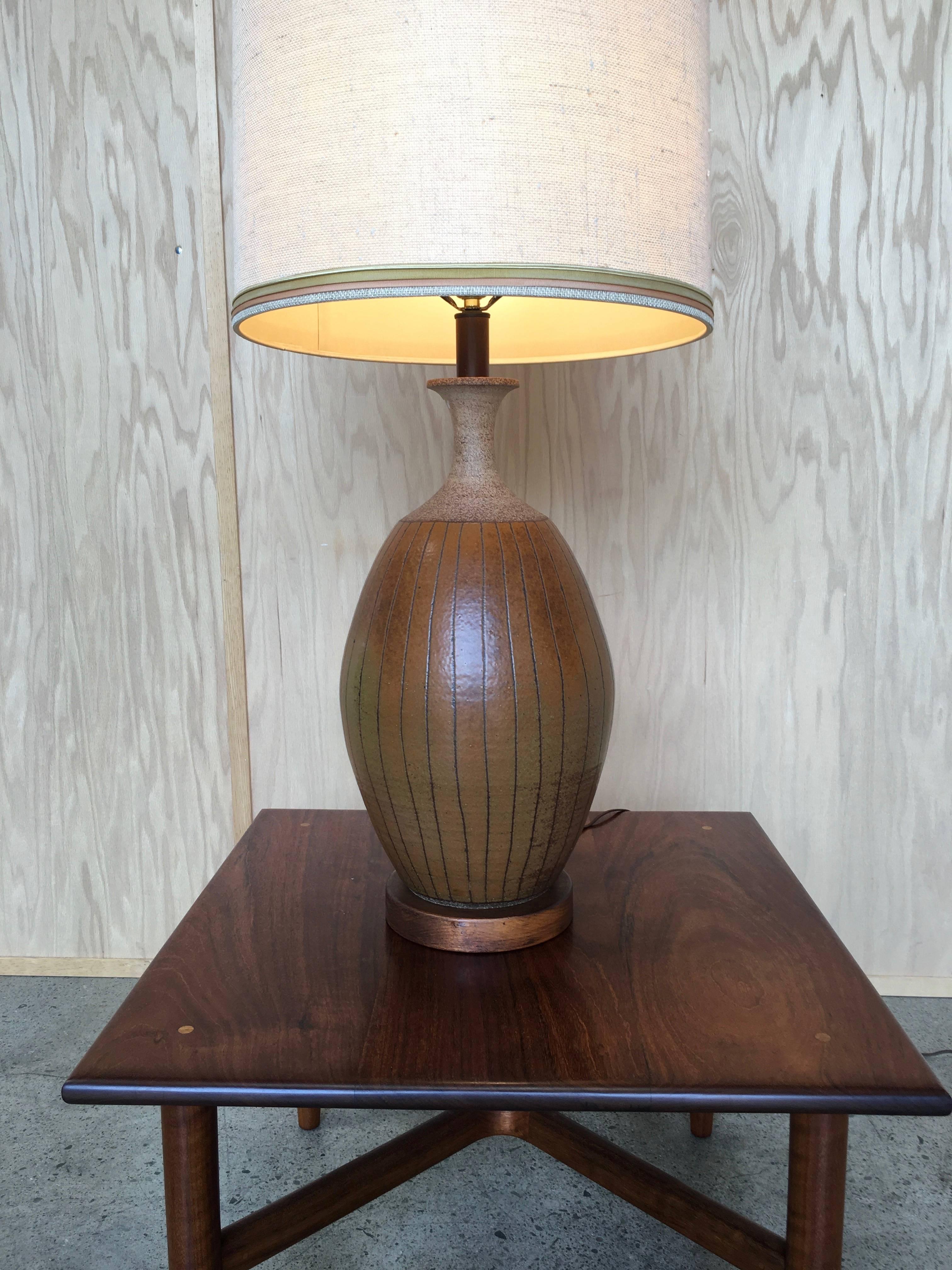 1960s, ceramic table lamp by Brent Bennett with wood base 
The shade is original but client might want to replace 
The base is 11" wide and 26" high to the top of the socket.