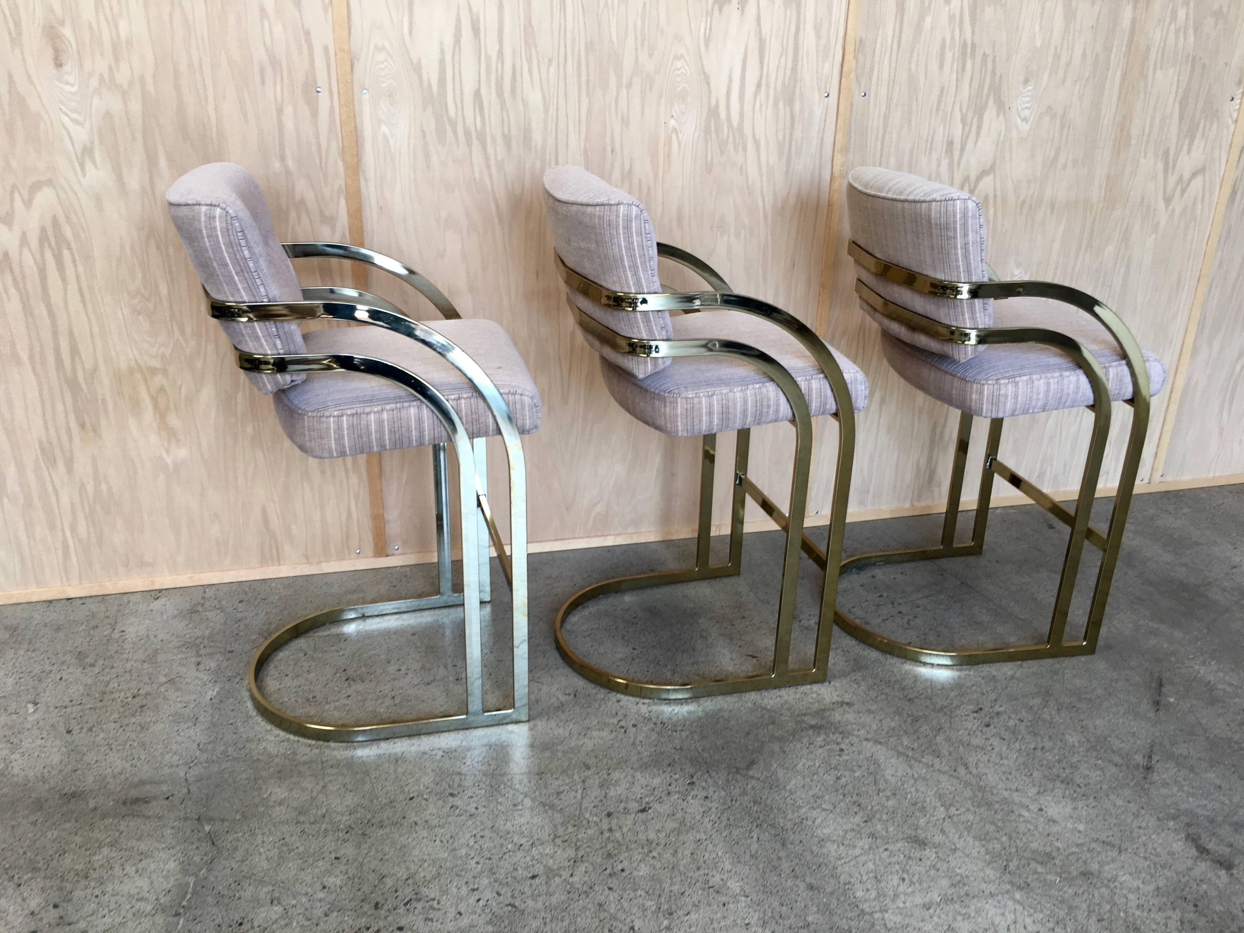 Set of three brass cantilever bar stools.
   