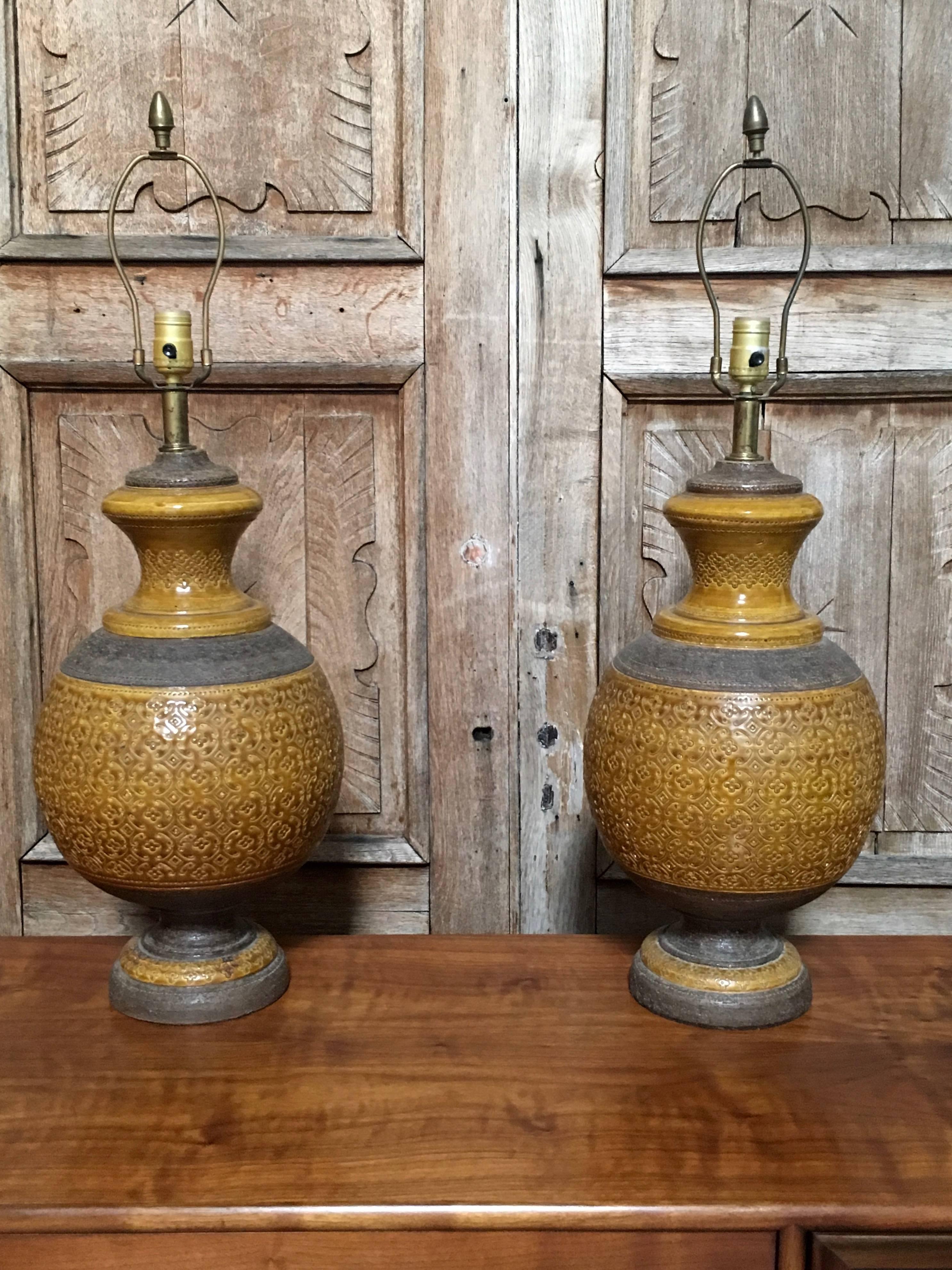 A fantastic pair of glazed mustard with natural colored ceramic lamps from the 1960s there are no shades included 31 inch high to top of the harp.