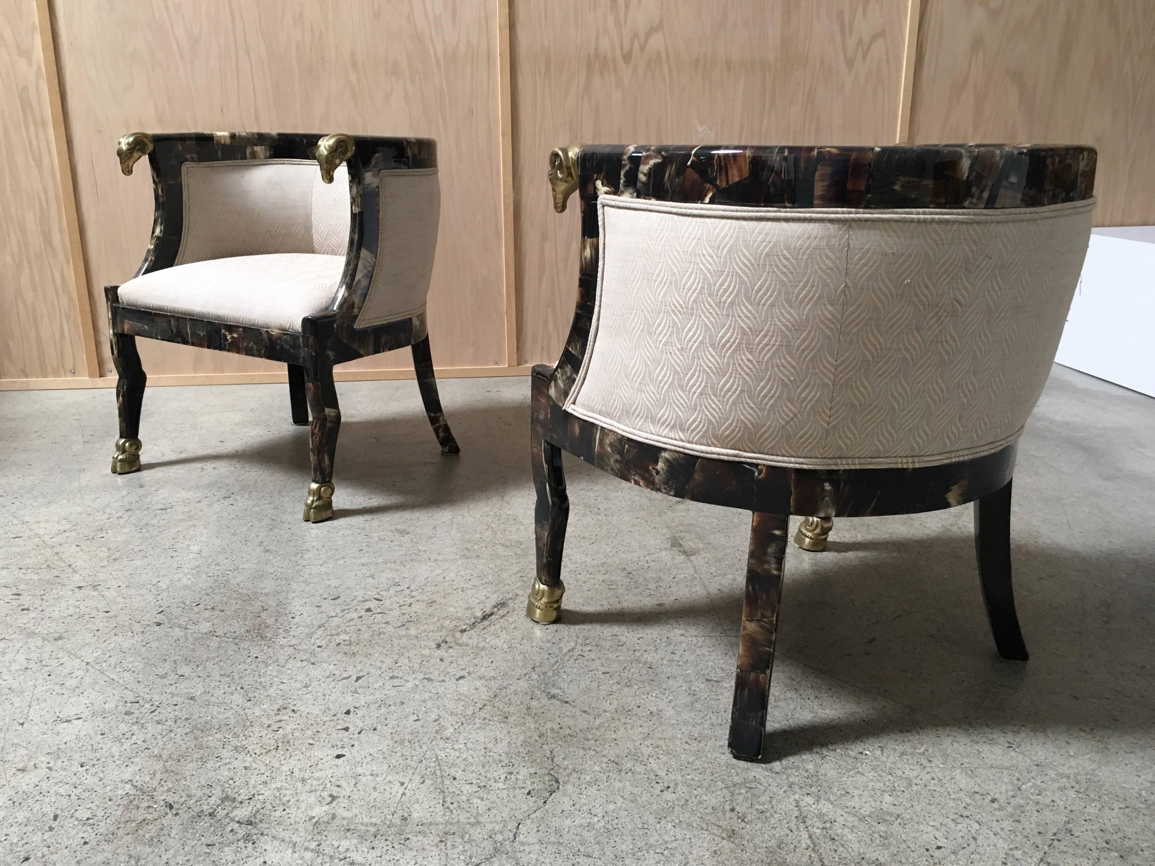 Pair of steer horn covered barrel chairs with brass ram heads and feet.