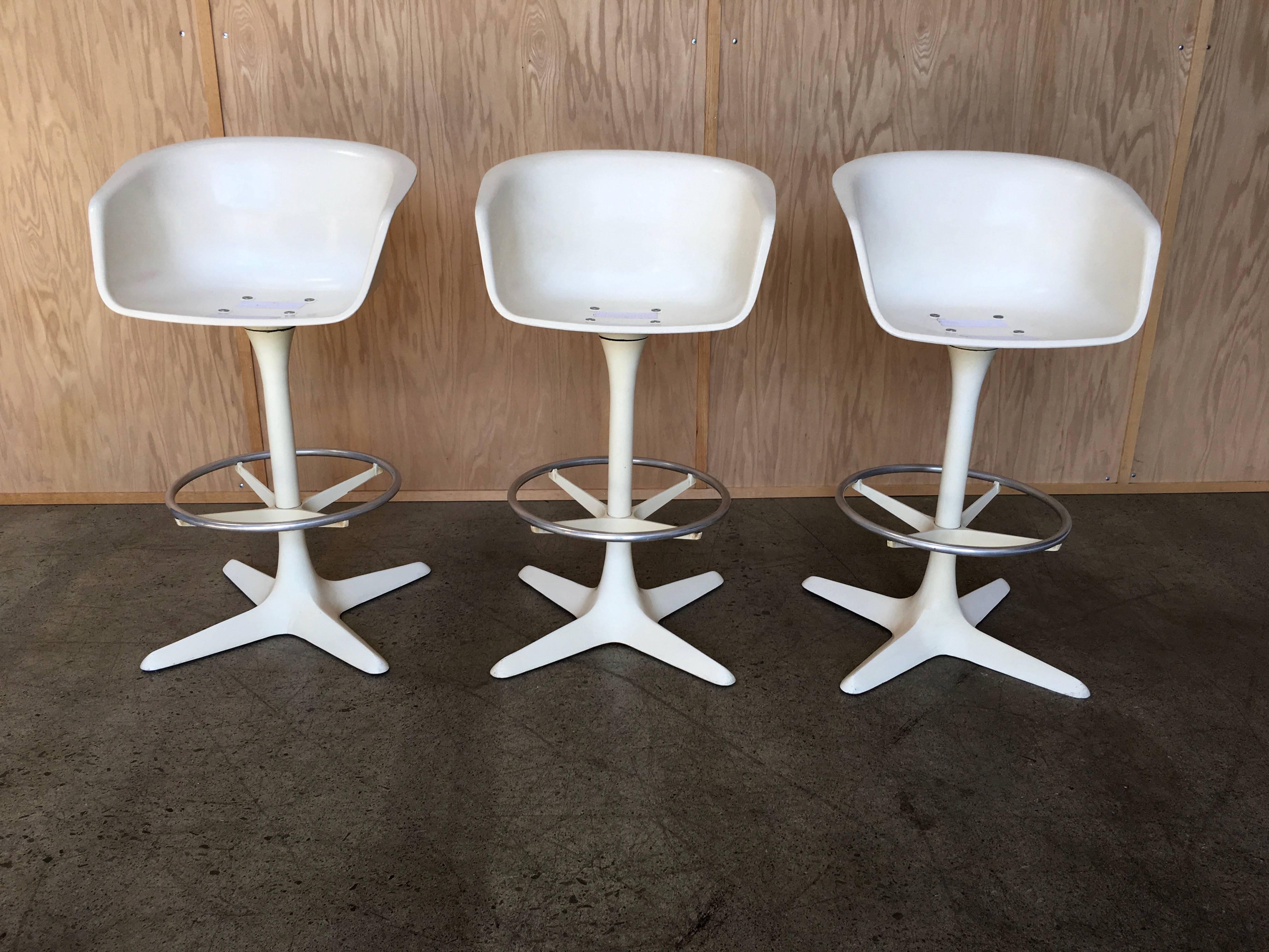 Made by Burke of Dallas a set of three swivel barstools fiberglass seats and powder coated aluminum base seat height is 28.25.
