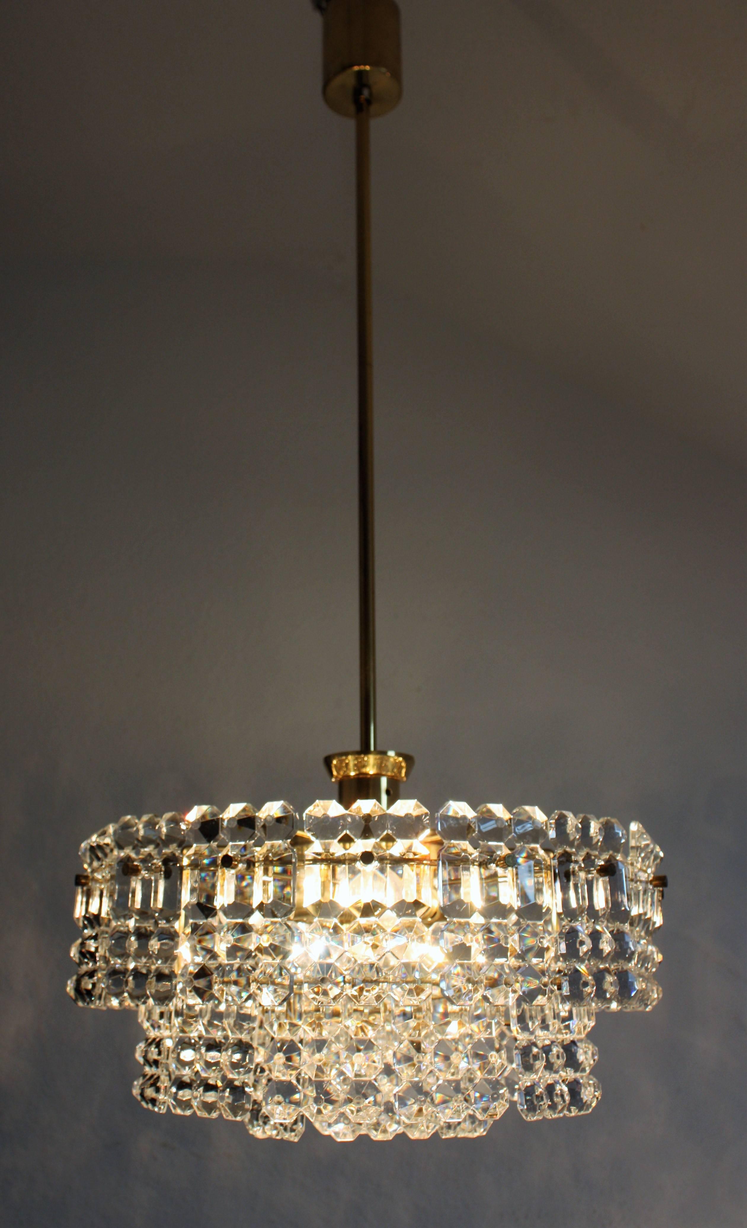 Beautiful and modern high quality seven-light crystal chandelier by Kinkeldey, Germany, circa 1960s.
Three-tier chandelier with geometric crystal on the brass frame. Height can be shorten in the middle of the chain.
Socket: Six x E14 and one x E27 