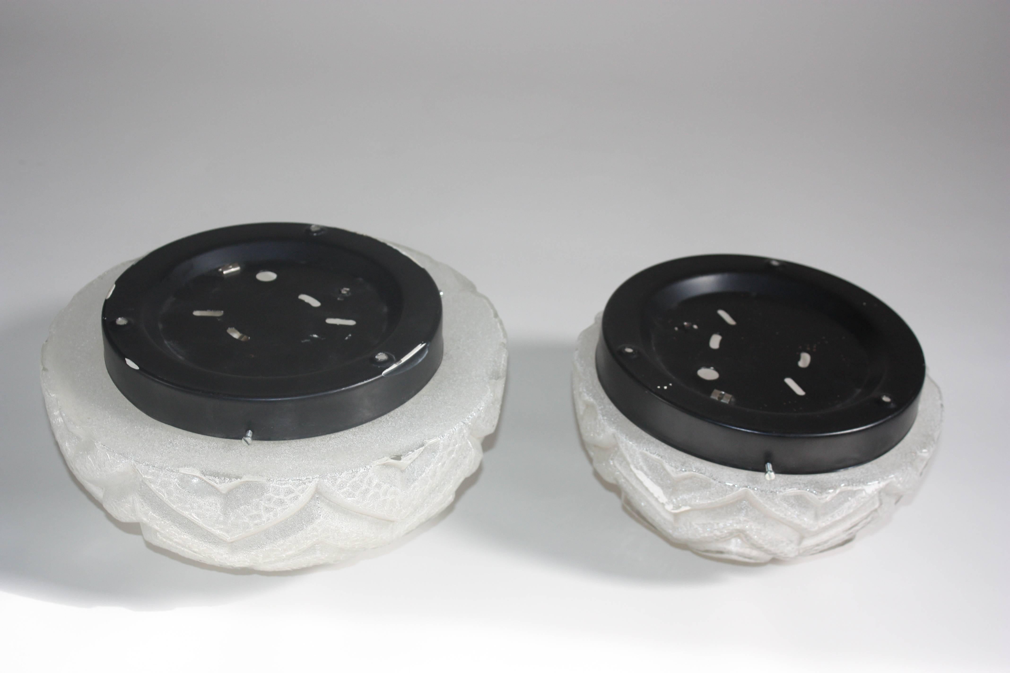 Pair of Mid-Century flush mounts in two sizes.
Textured glass and black painted metal frame.
Germany, circa 1960s.
Very good condition.
Socket: E 27 standard 

Measures: 9.8 