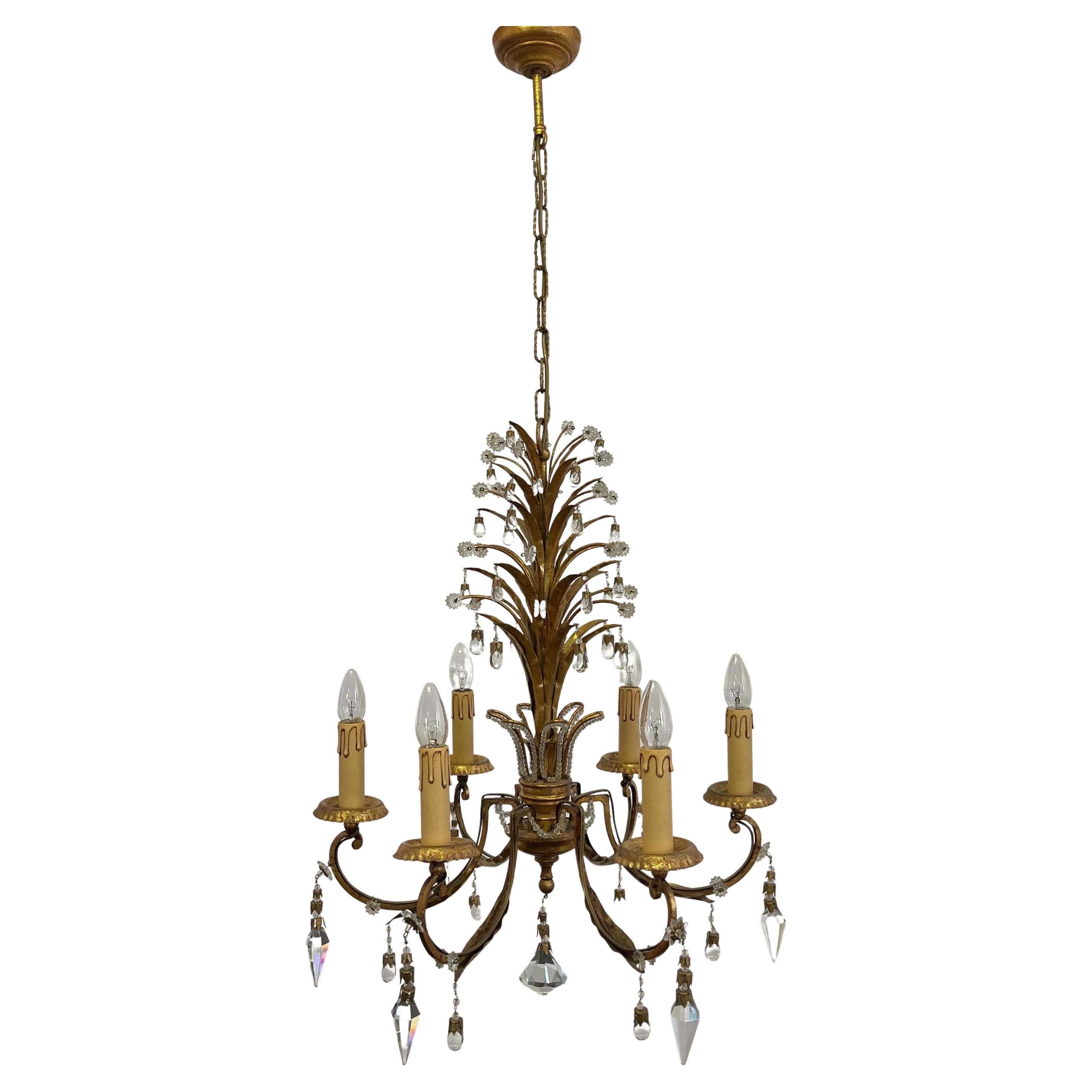 A hollywood regency style chandelier by Giovani Banci, Italy, circa 1970s.
This beautiful handcrafted chandelier is made of patinated and gilt iron, decorated with lead crystals tear drops and prism.
Measurements: totally height 47.24 inches,