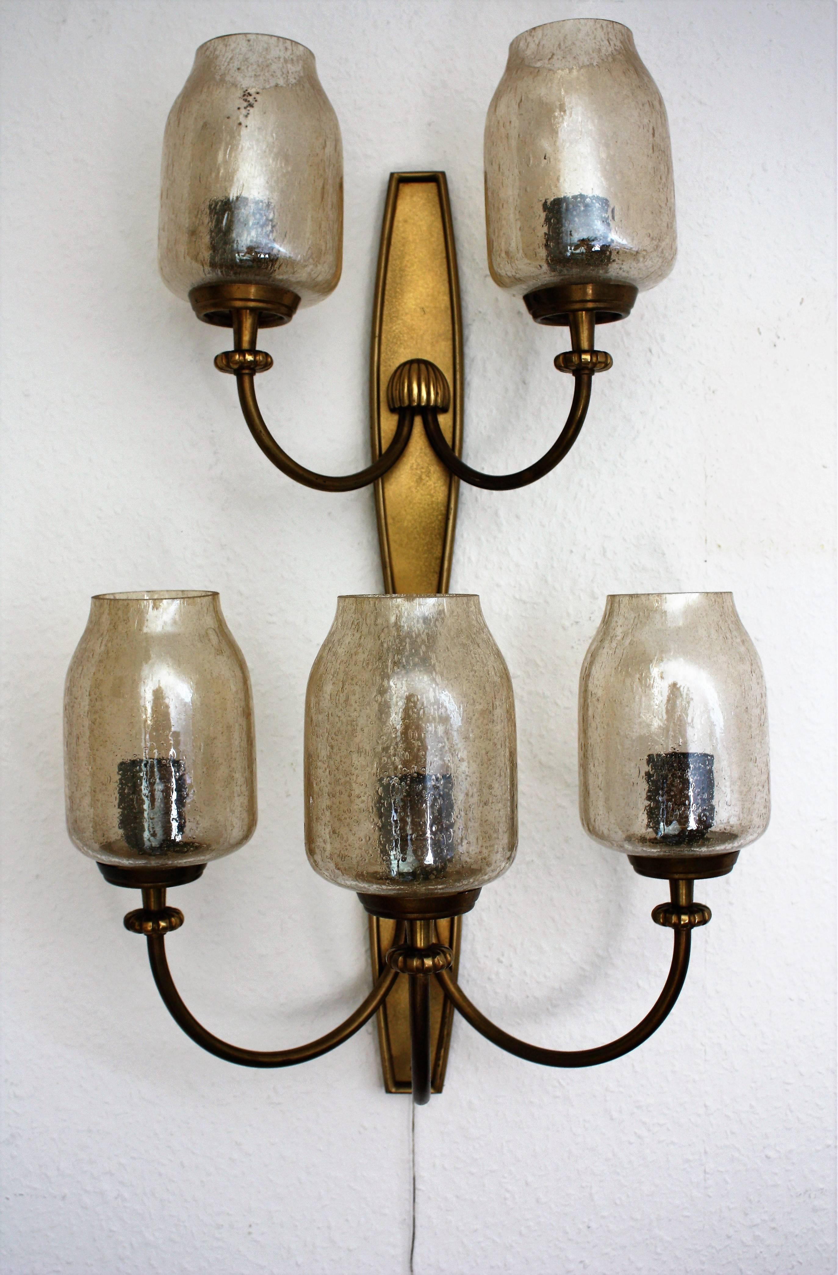 Stunning set of Art Deco brass and glass wall sconces with following measures:
five-light sconce: 24.8" x 16.5"
three -light sconce: 13.3" x 16.5"
two -light sconce: 13.3" x 12.2" (has more patina)
Socket: each E