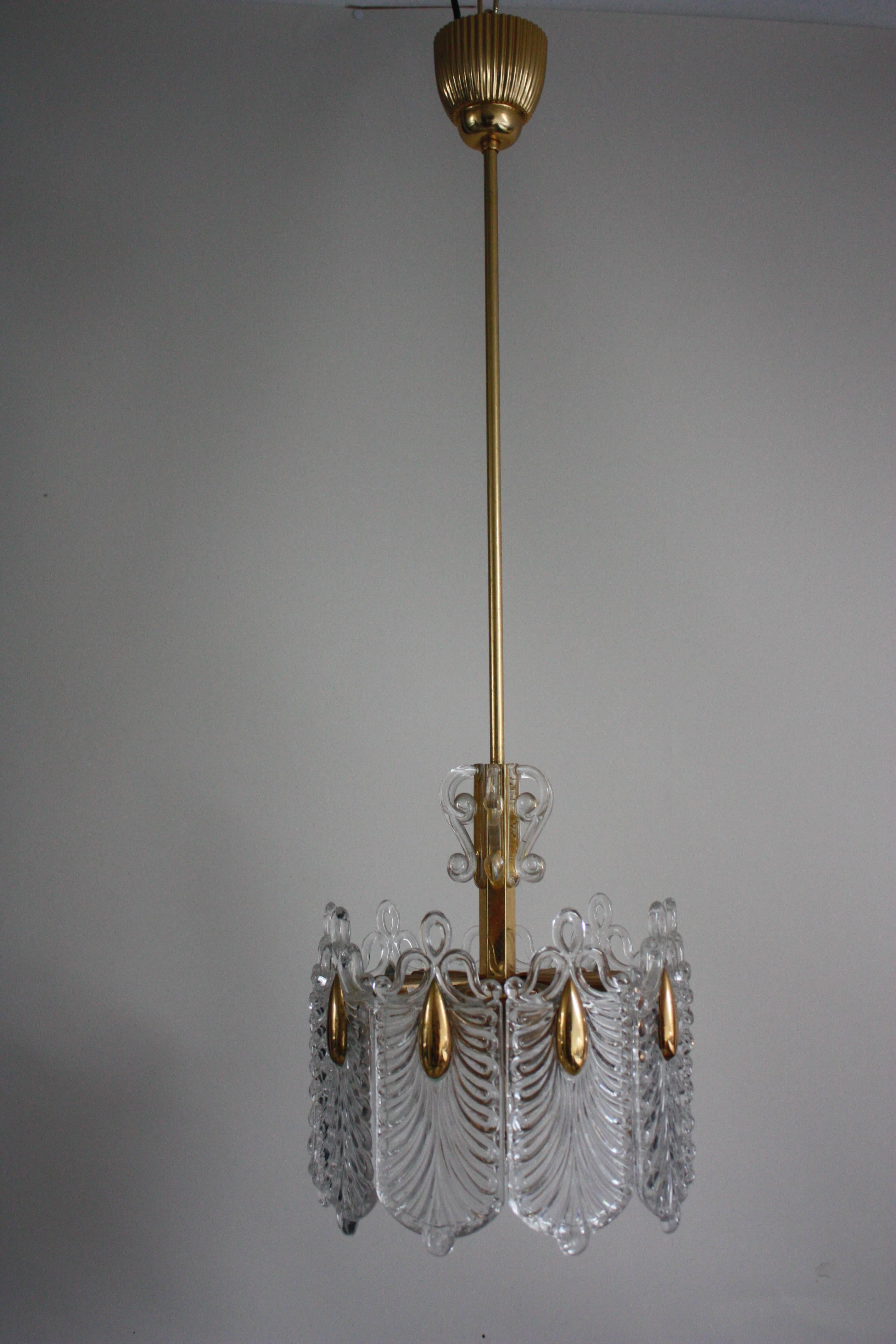 A fin, elegant mid-century three-light glass chandelier by Kaiser, Germany, circa 1960s.
Made of gilt brass and metal frame with textured clear glass.
Sockets: 3 x e27 for standard screw bulbs. Rewired for US.