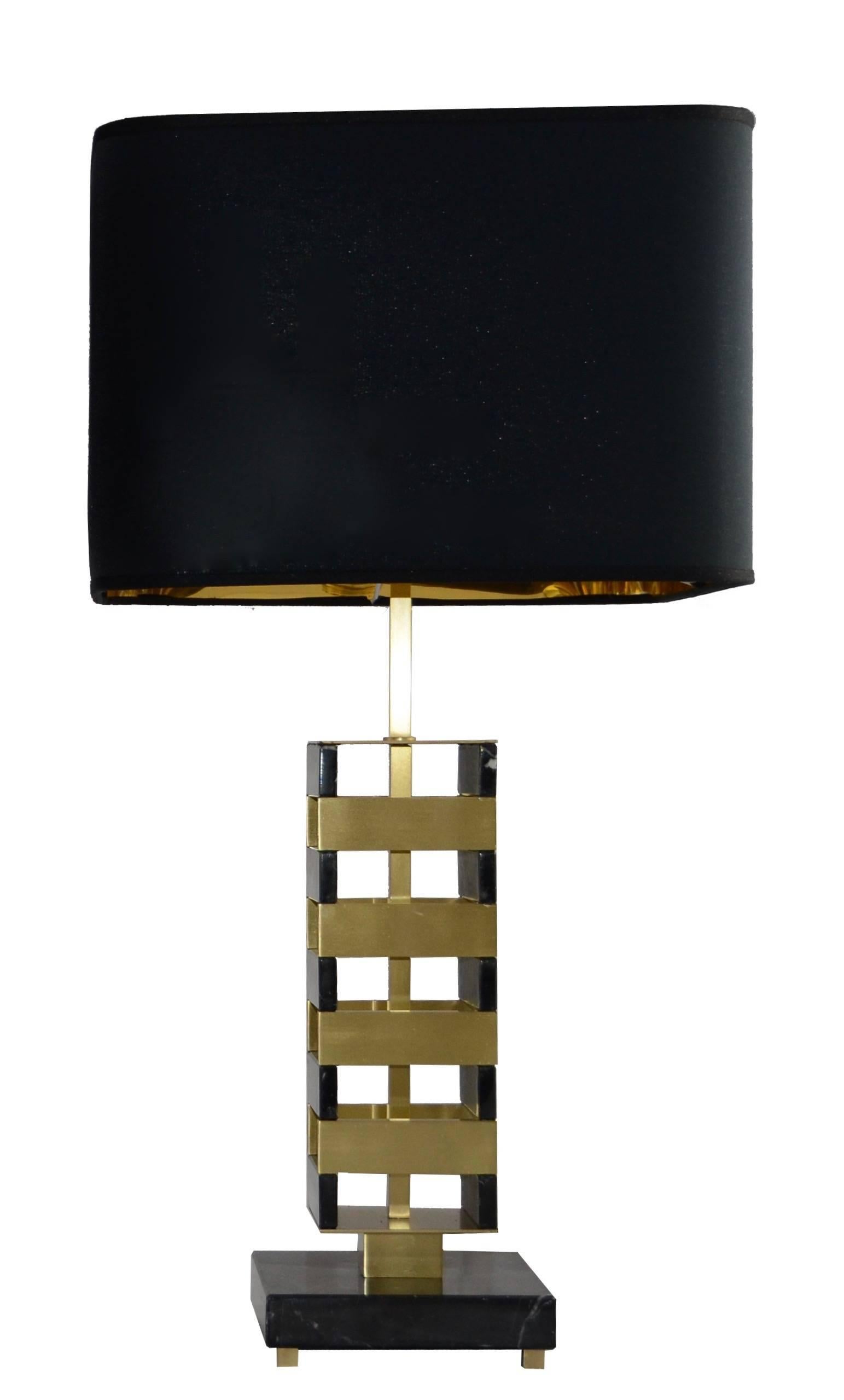 This table lamp is the combination of modernism and precious materials.
The marble and satin brass column is placed on a black Marquinia marble, the black squared silk shade makes this piece very elegant. This model can be placed in a modern
