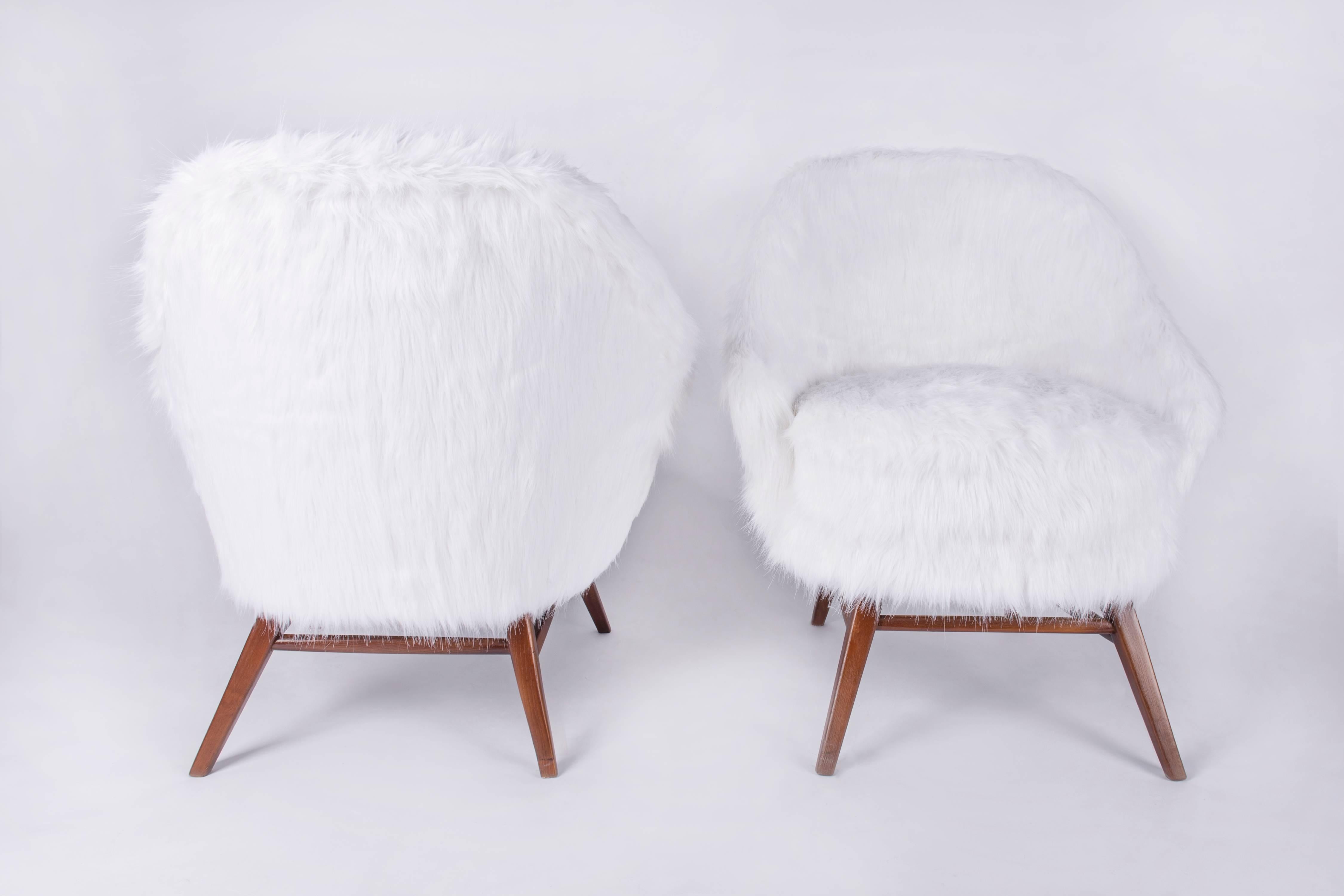 Pair of Mid-Century Modern armchairs, fully restored. The chairs were re furbished, completely re upholstered with a white long hair faux fur. The wooden structure was repolished. The cussins are with springs. Perfect comfort. An ideal piece to be