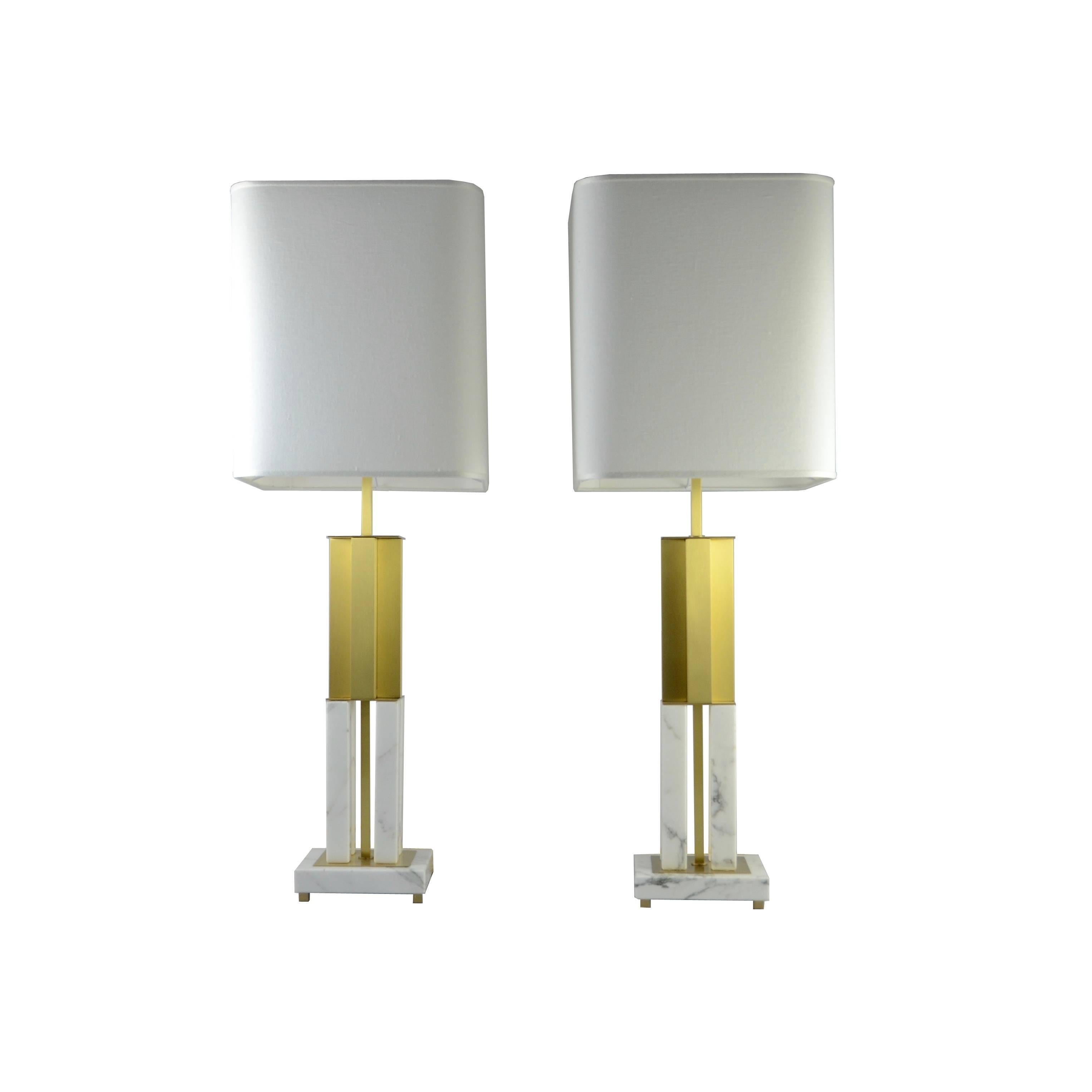 This table lamp is the combination of modernism and precious materials.

The polished Calacatta marble base holds a satin brass part. The ivory linen squared lampshades are covered inside with a milky white colored layer. The shades can be