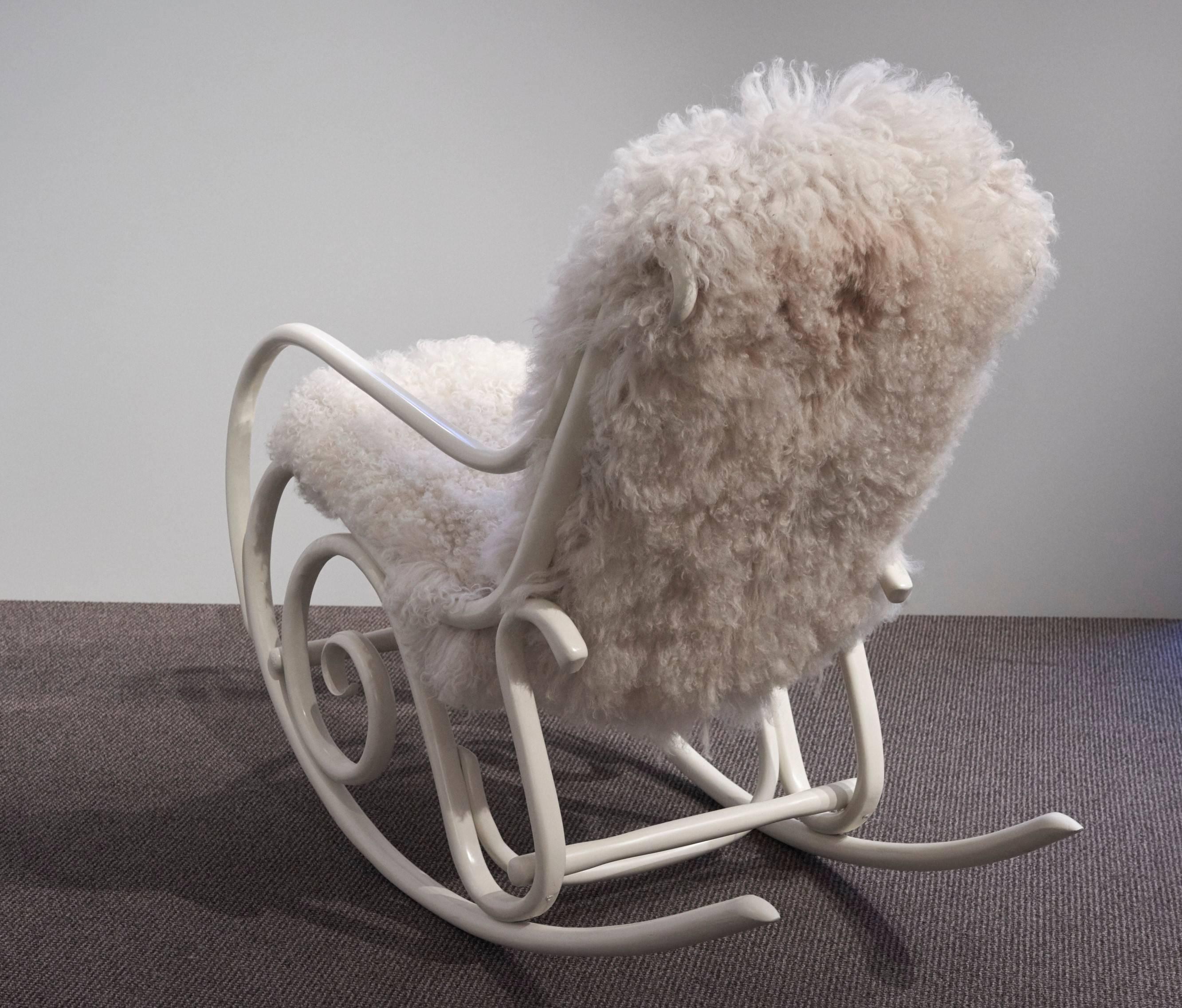 Bentwood rocking chair model N°21 designed in 1860 for Thonet.
This authentic piece is finished with an ivory lacquer and reupholstered with a white colored long hair lamb fur.