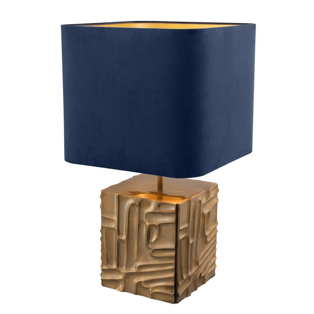 Aged brass base table lamp with midcentury architectural style motif and blue velvet lamp shade. Stylish as a pair for bedroom nightstand tables, in general living spaces posed on couch framing side stables, posed on entry consoles or the fireplace