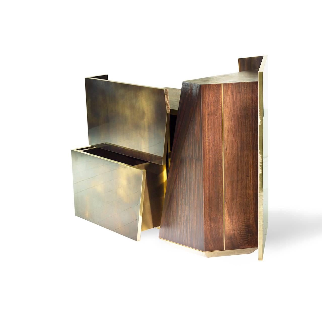 A work of art for the bedside, this modern piece uses angled and contrasting lines to define its drawers and hidden cabinet space. Hand finished solid brass, blackened chrome and solid walnut, teak and mahogany woods combine to define its forceful