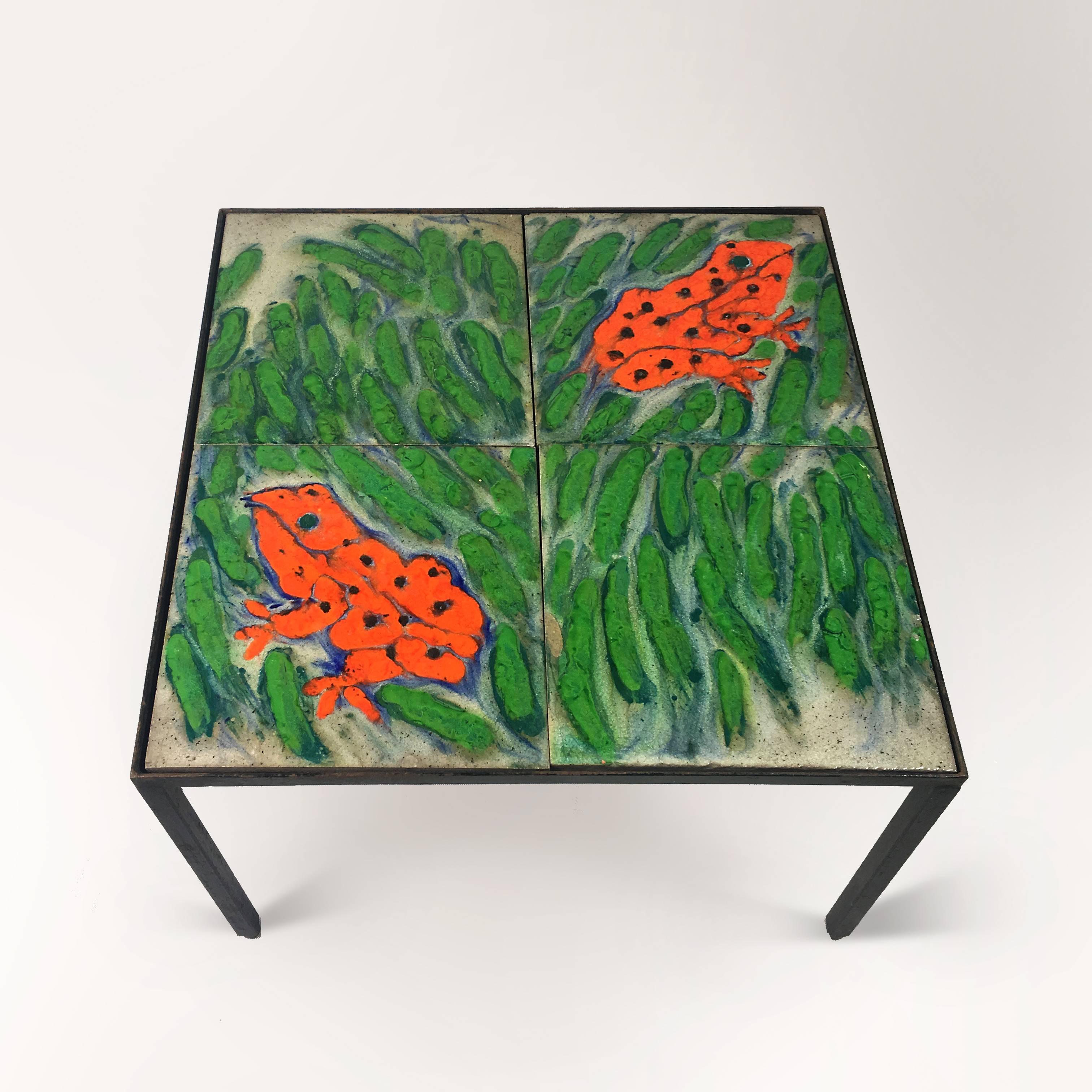 Bright square coffee table of 1960s. Metal base, decorated with four hand-painted glazed ceramic tiles. The symmetrical drawing depicts two neon-orange frogs in the green grass.
Unknown artist.