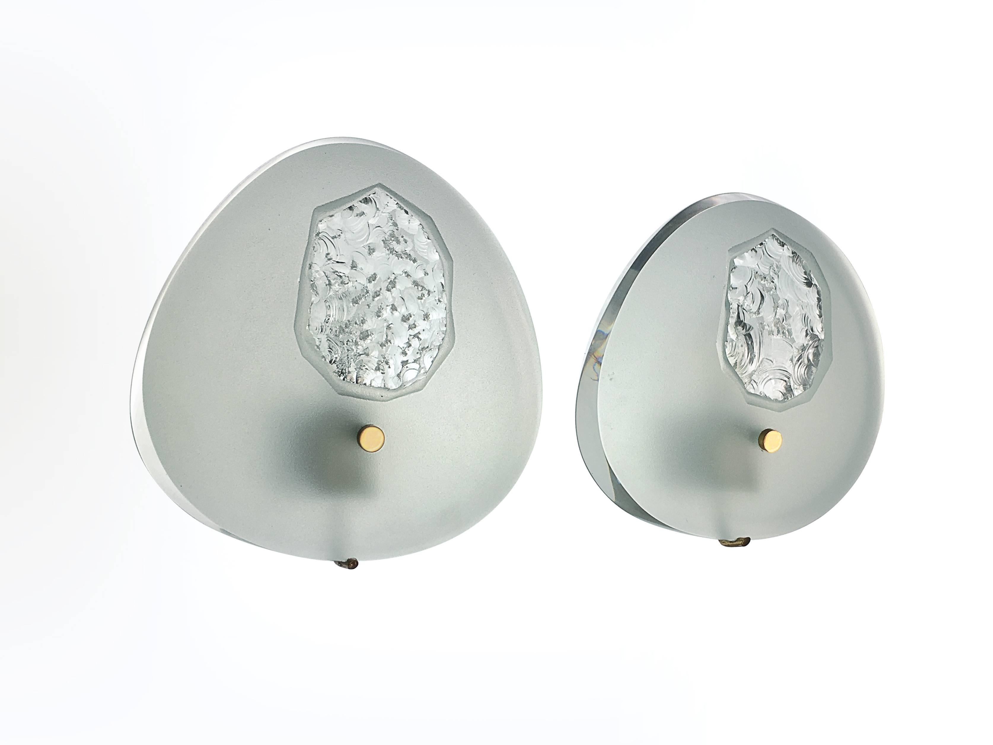 Soft shaped sconces designed by Max Ingrand, made of polished and frosted glass with sculpted centre. Mounts are made of brass.
    